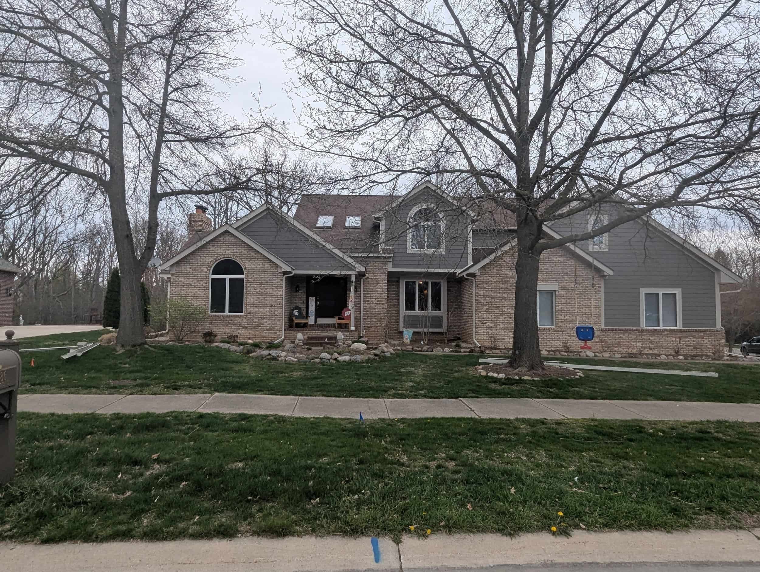 James Hardie siding with stone accents on large suburban home with mature landscaping