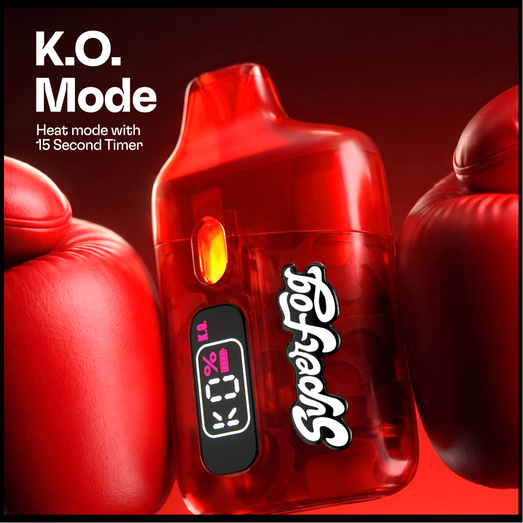 A red laser device labeled 'SuperFly Fog' with digital screen showing 'K.O.', 0% battery, and '15 KL'. Flanked by red boxing gloves against a dark background, promoting a heating fog machine with a 15-second timer.