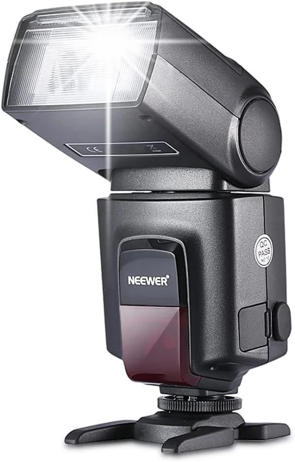 A large, professional camera flash head with a reflective silver interior is shown on a stand.