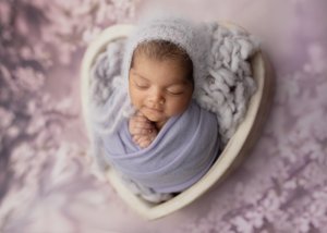 Newborn in a grey knit bonnet swaddled in lavender in a white heart bowl, Mountain View newborn photographer