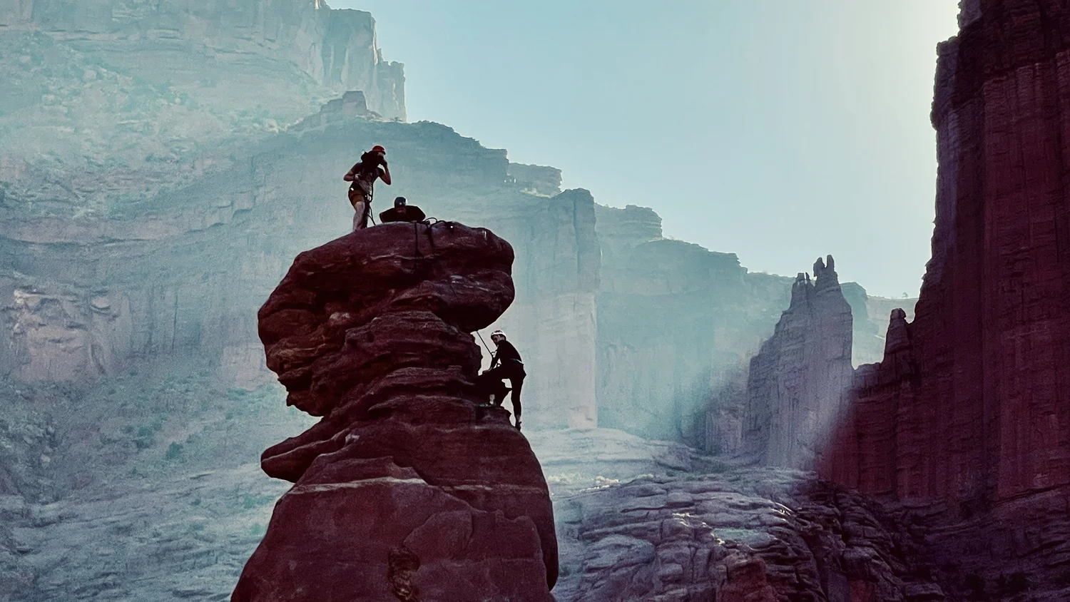 Climbers high above the desert in Moab
