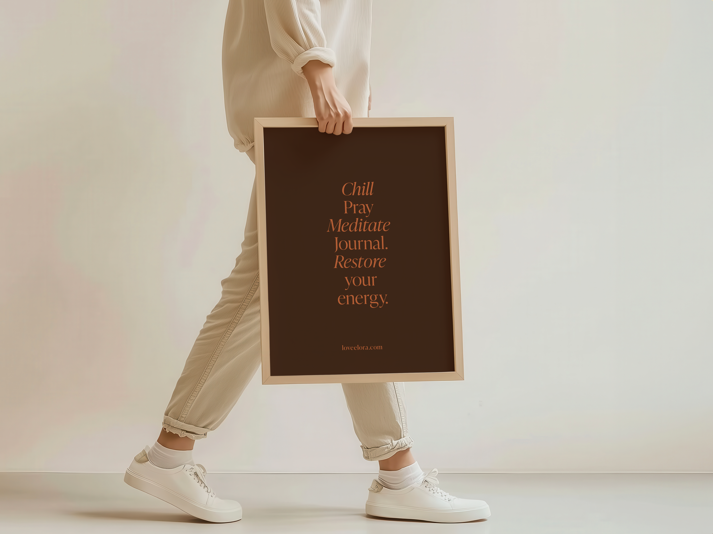 Person holding an elora motivational quote print reading ‘Chill, Pray, Meditate, Journal, Restore your energy.’ Styled with neutral clothing and a minimalist aesthetic for an intentional living space.