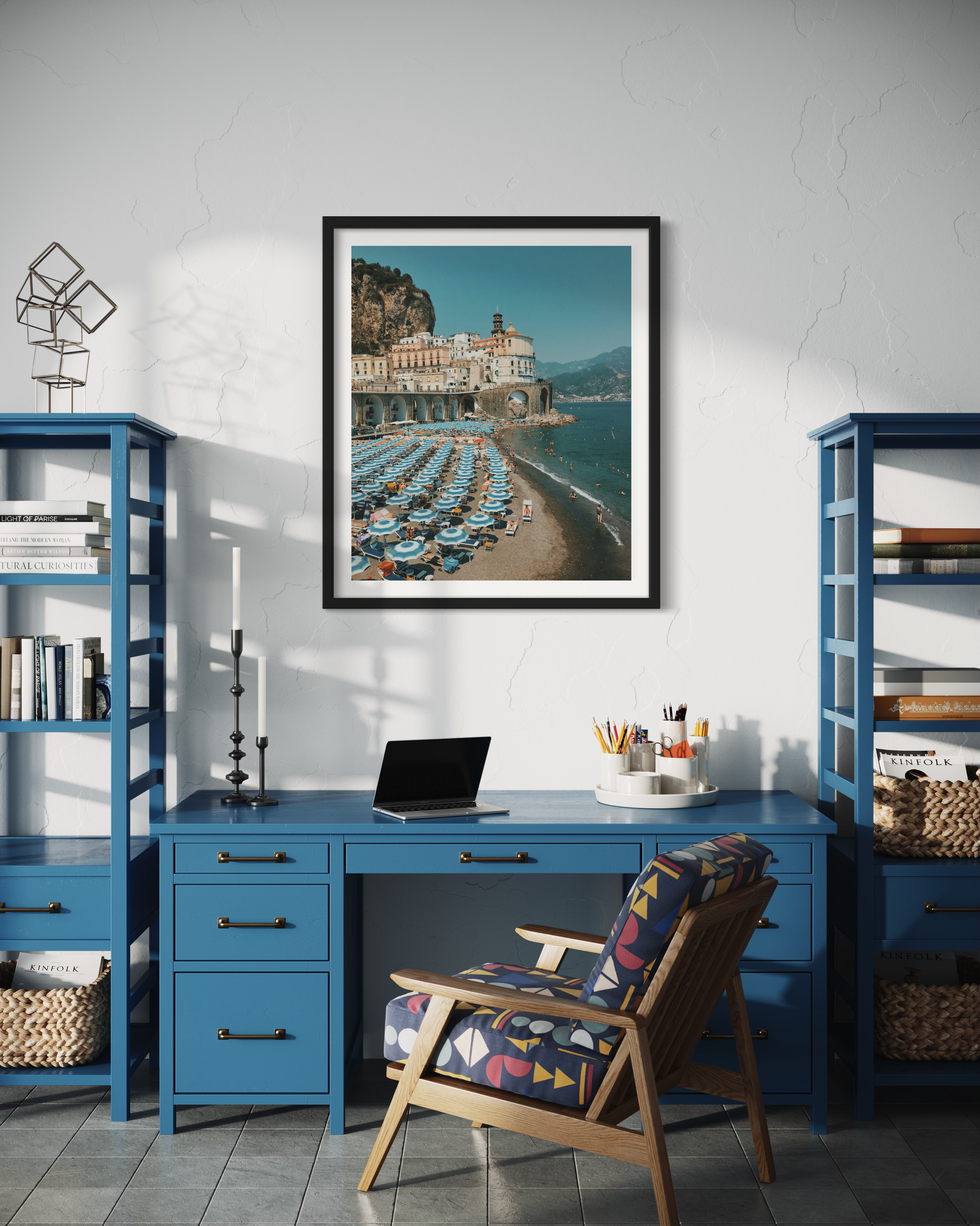 The photo captures the picturesque beauty of the Amalfi Coast, featuring a pristine beach adorned with vibrant blue Monterroso umbrellas.