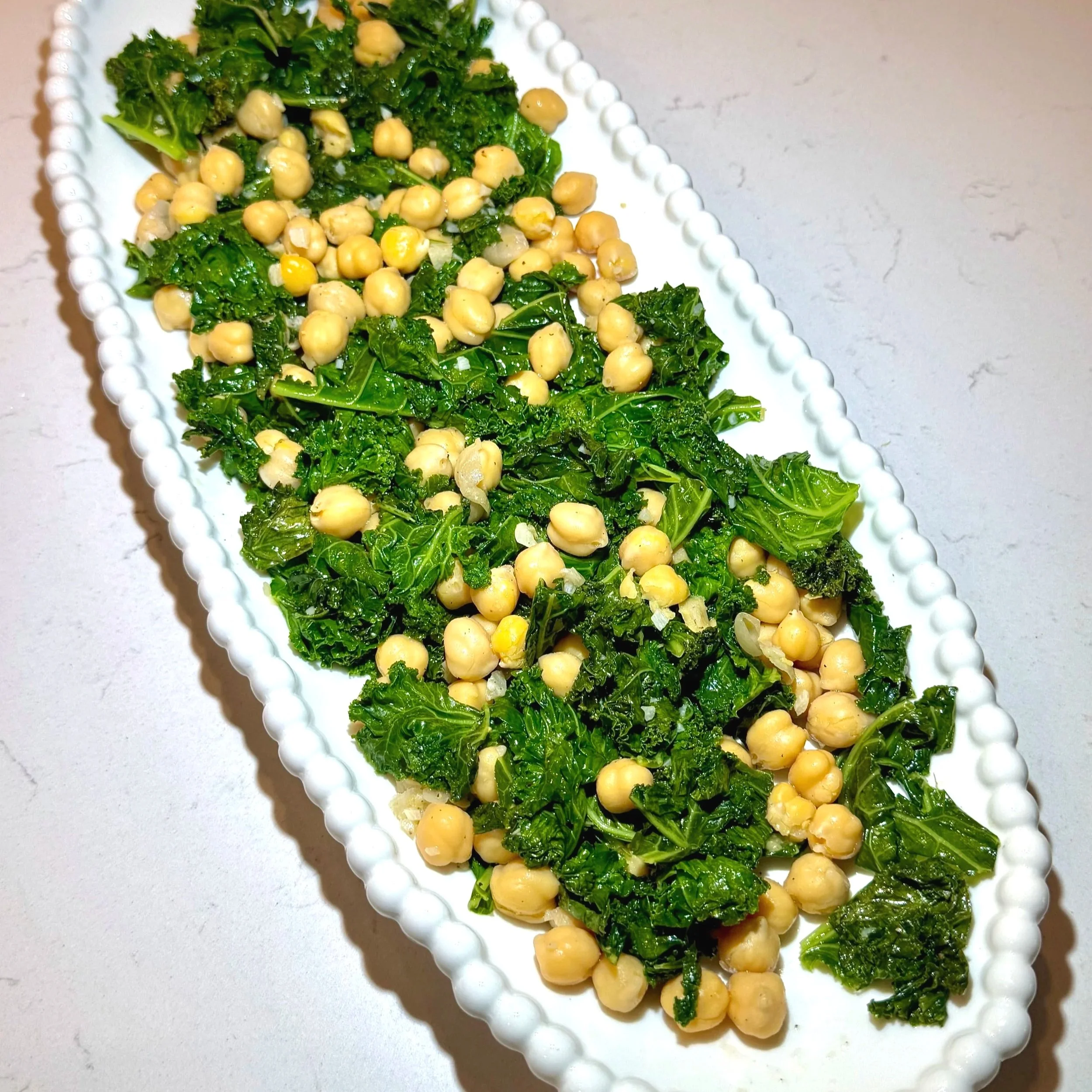 Sautéed kale and chickpeas glistening with olive oil and lemon.