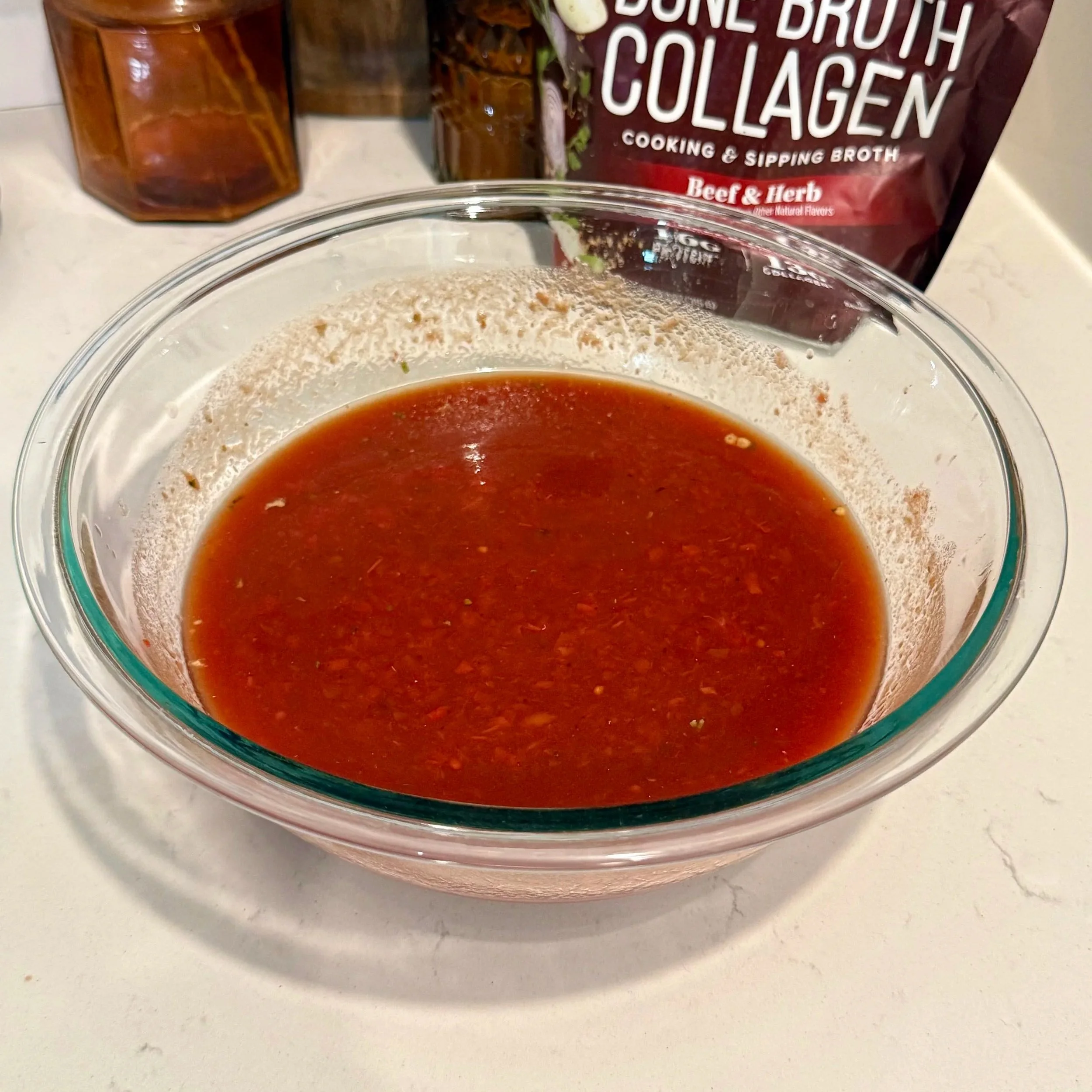 Rich tomato and cream sauce for slow cooker beef brisket pasta, showing glossy texture and herbs before mixing with pasta