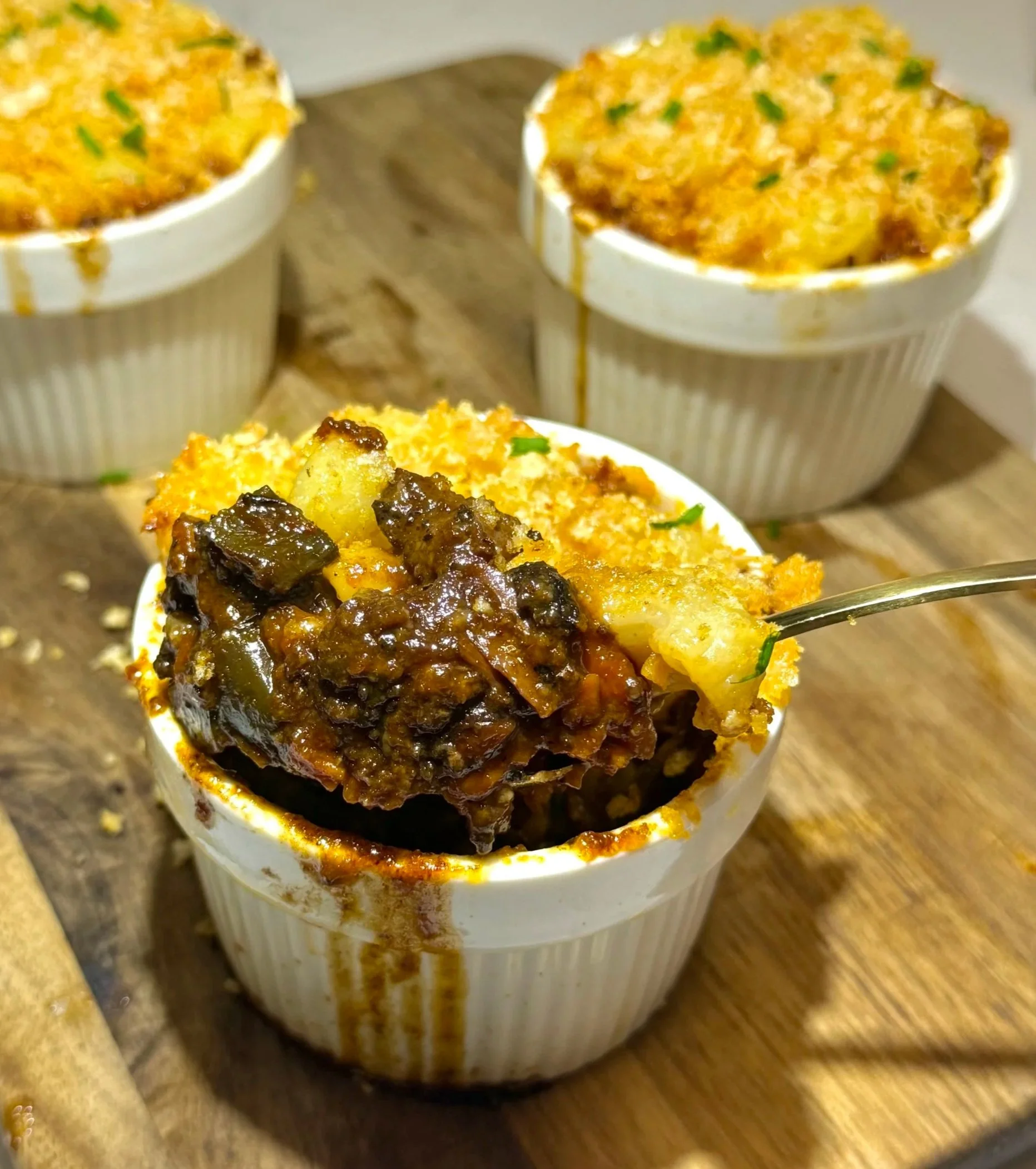 Spoon lifting Jamaican oxtail mac and cheese with creamy pasta and rich oxtail gravy