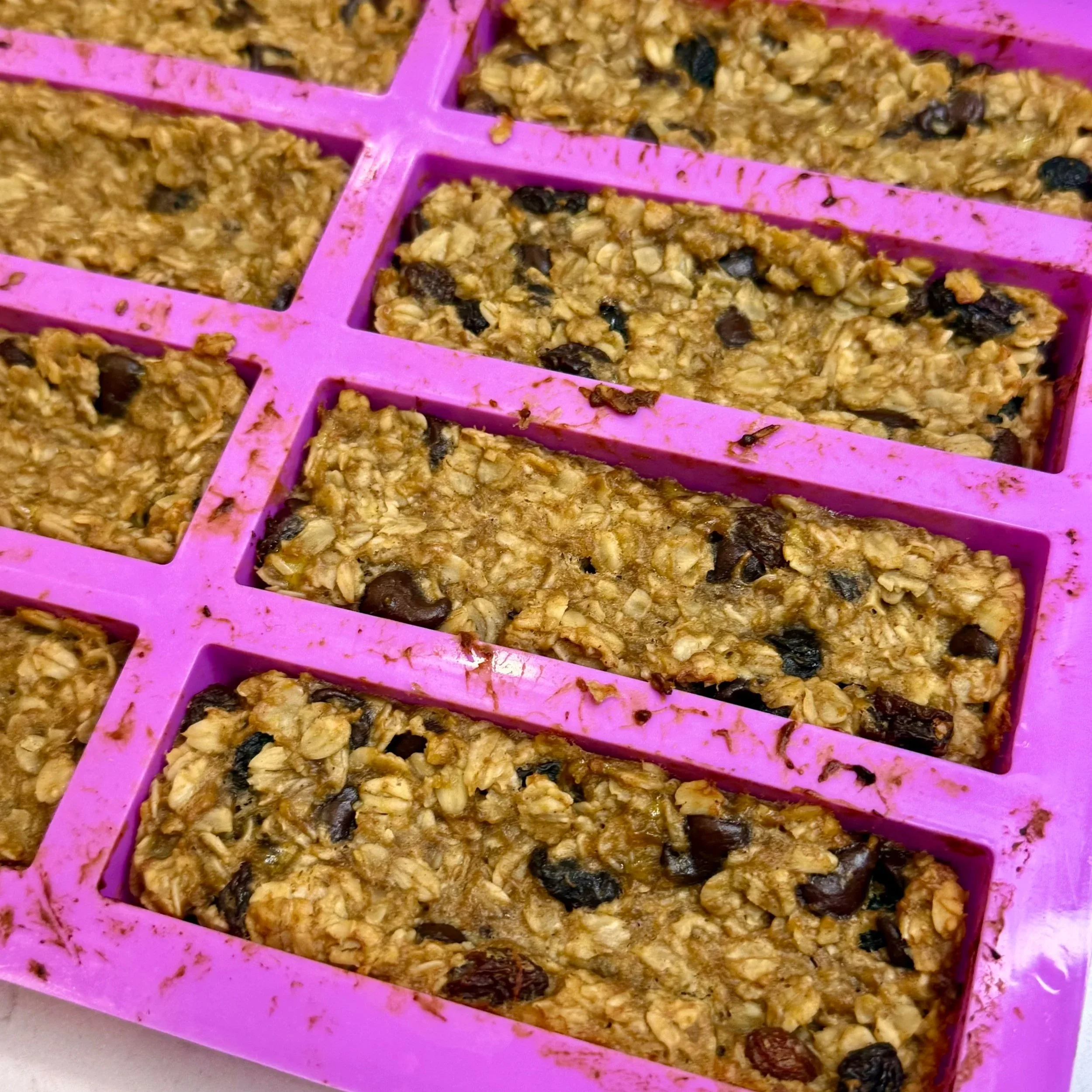 Freshly baked oatmeal banana bars cooling in a silicone mold.