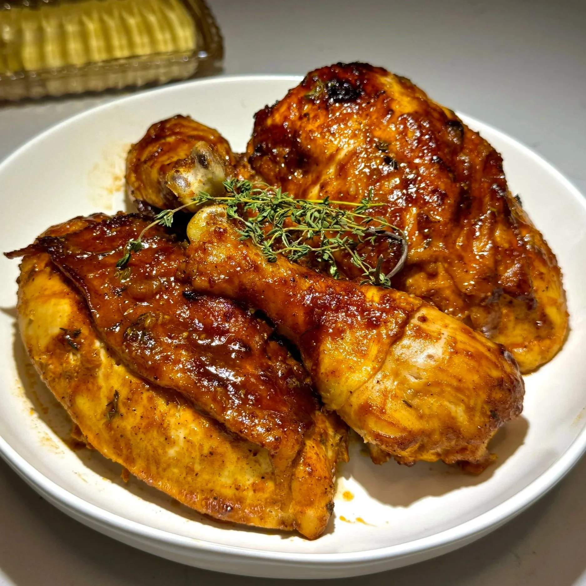 Finished lemon thyme baked chicken with golden skin, fresh herbs, and lemon slices.