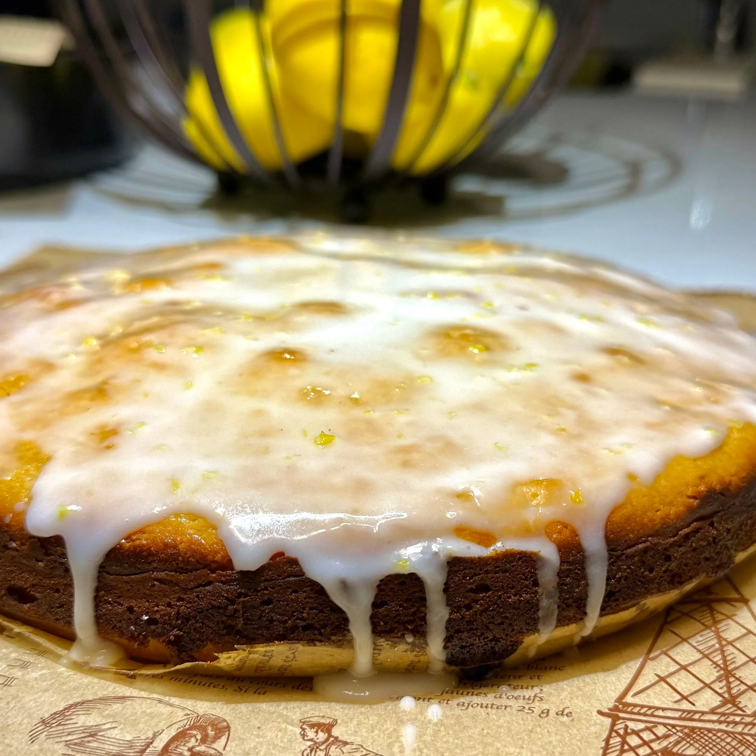 Lemon glaze dripping over lemon ricotta cake close up
