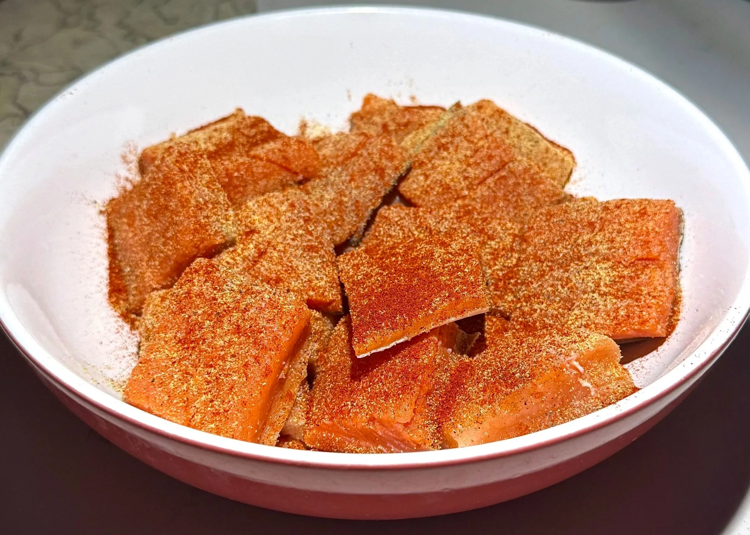 Cubed salmon seasoned with spices for a salmon rice bowl recipe