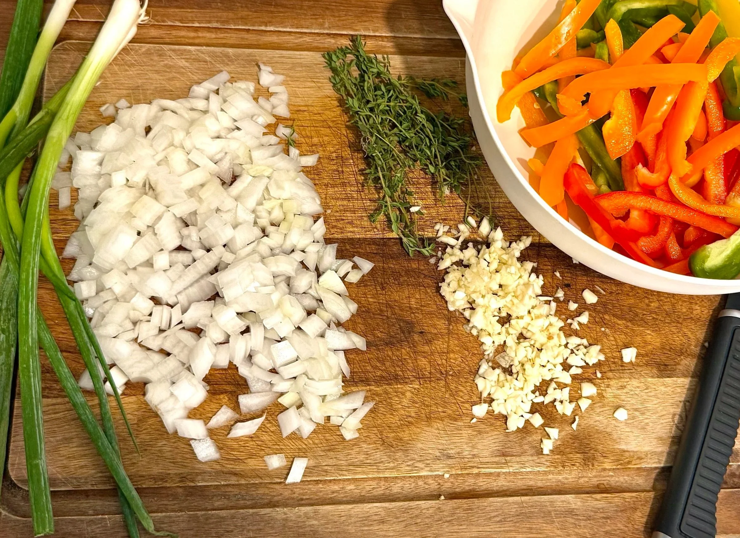 Fresh bell peppers, scallions, thyme, and jerk seasoning arranged for Jamaican Rasta Pasta