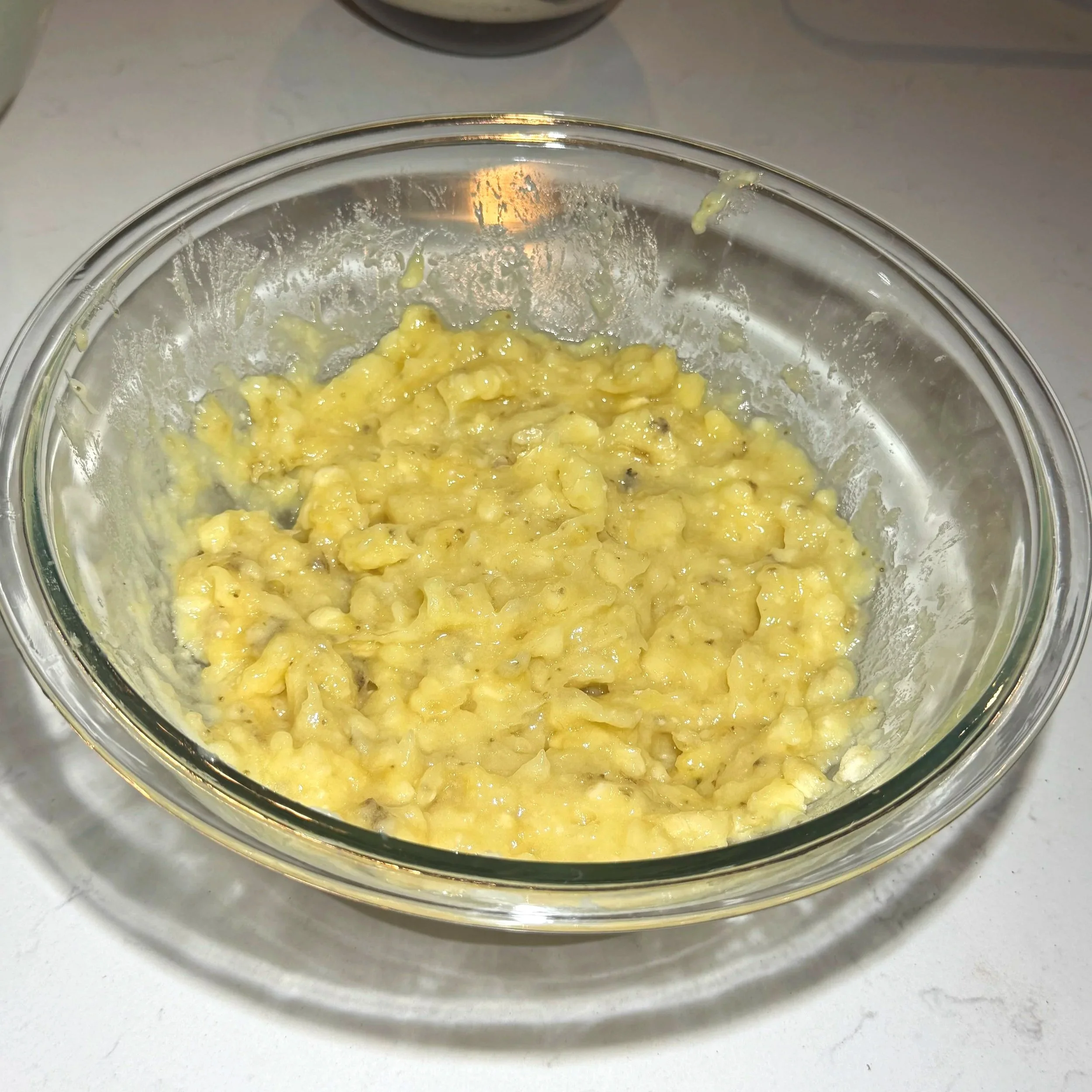 Ripe bananas mashed in a mixing bowl for banana bread