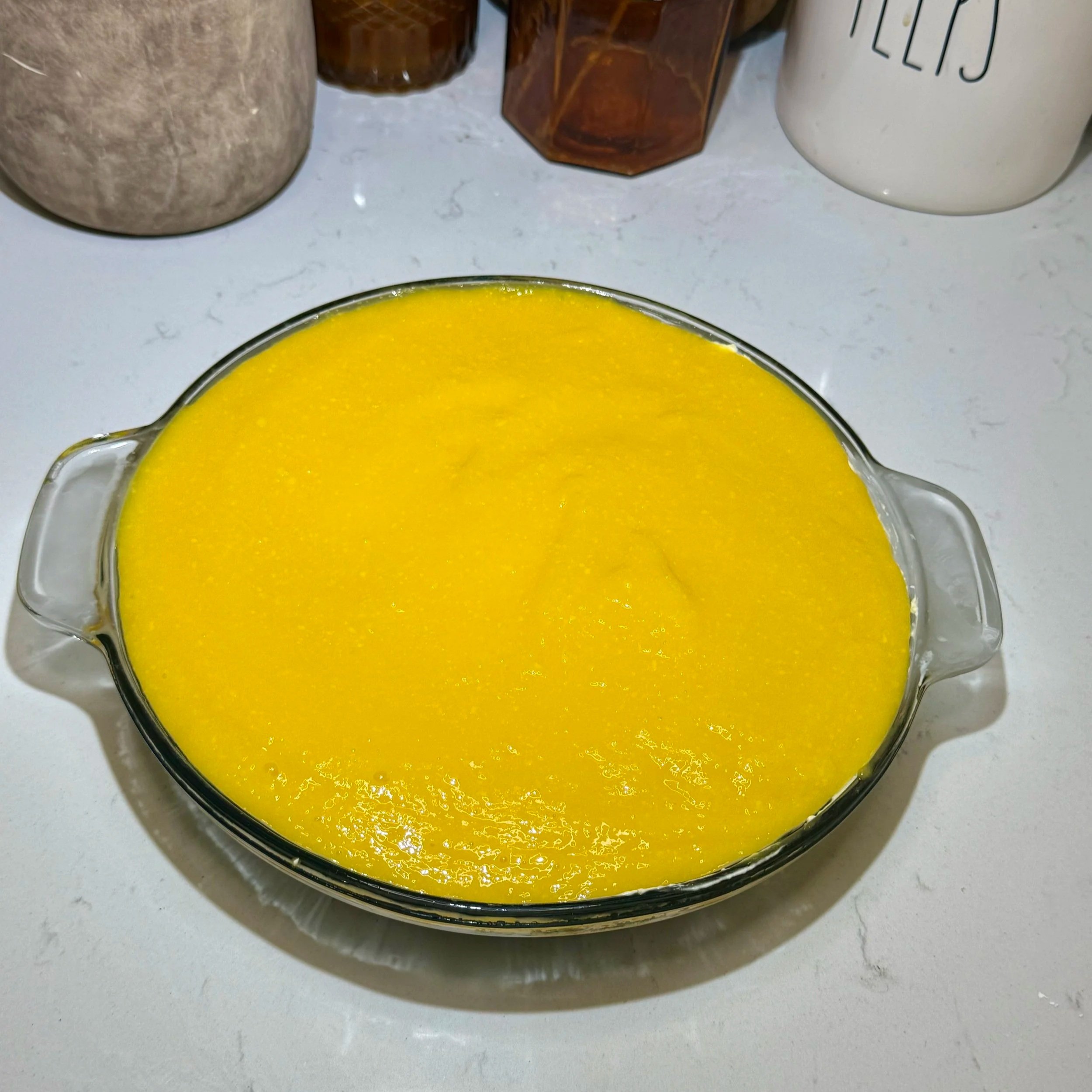 Bright mango layer poured and spread over the cheesecake filling