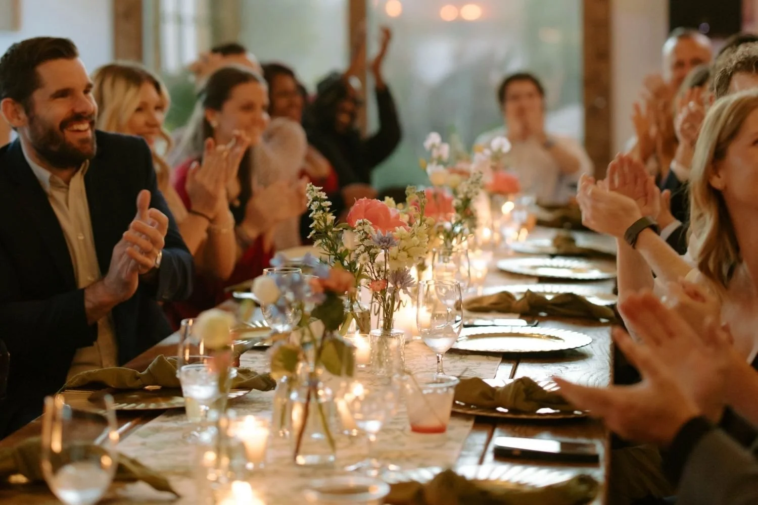 Wedding reception table with bud vases down the middle with colorful flowers