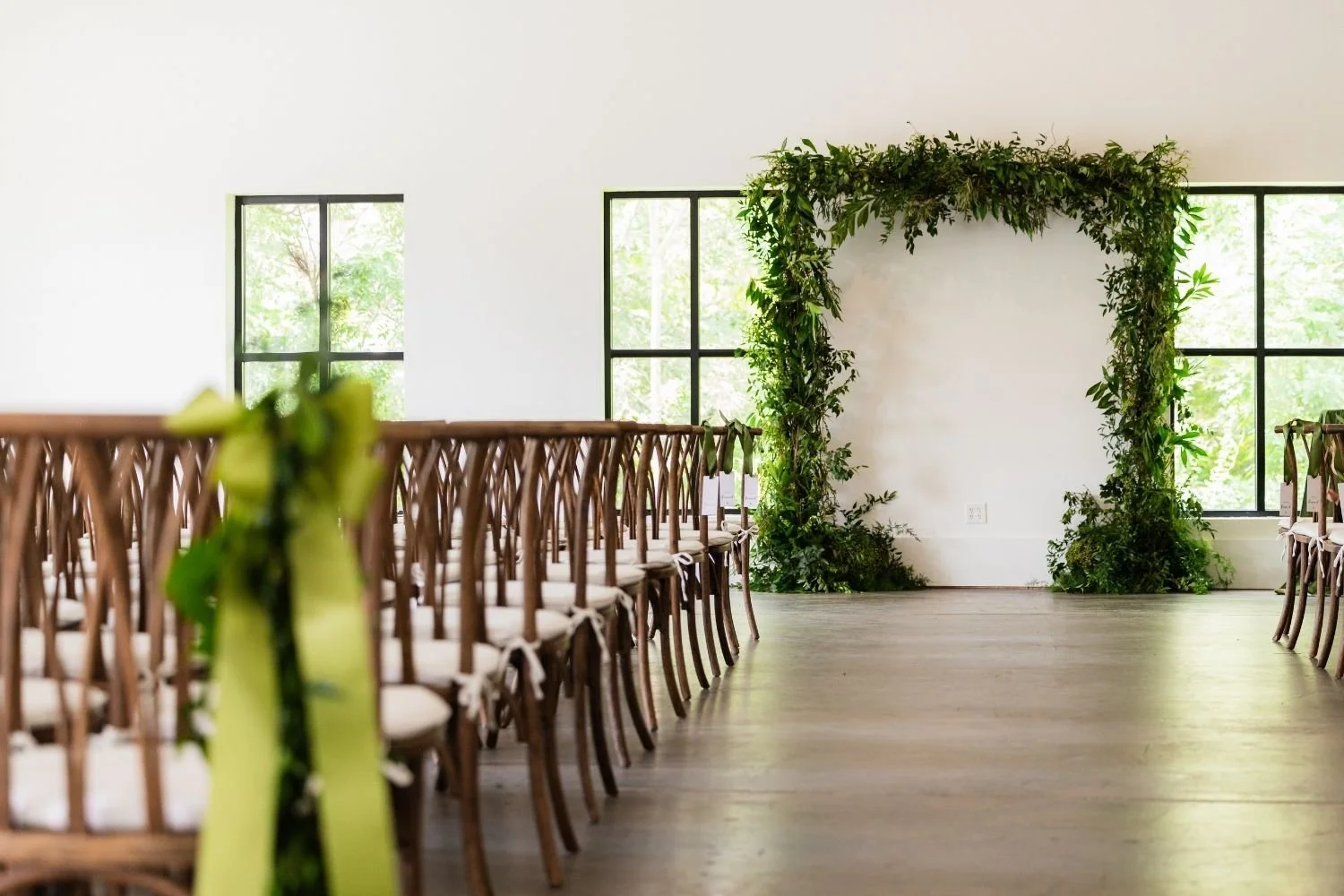 Wedding ceremony with a large square greenery arch