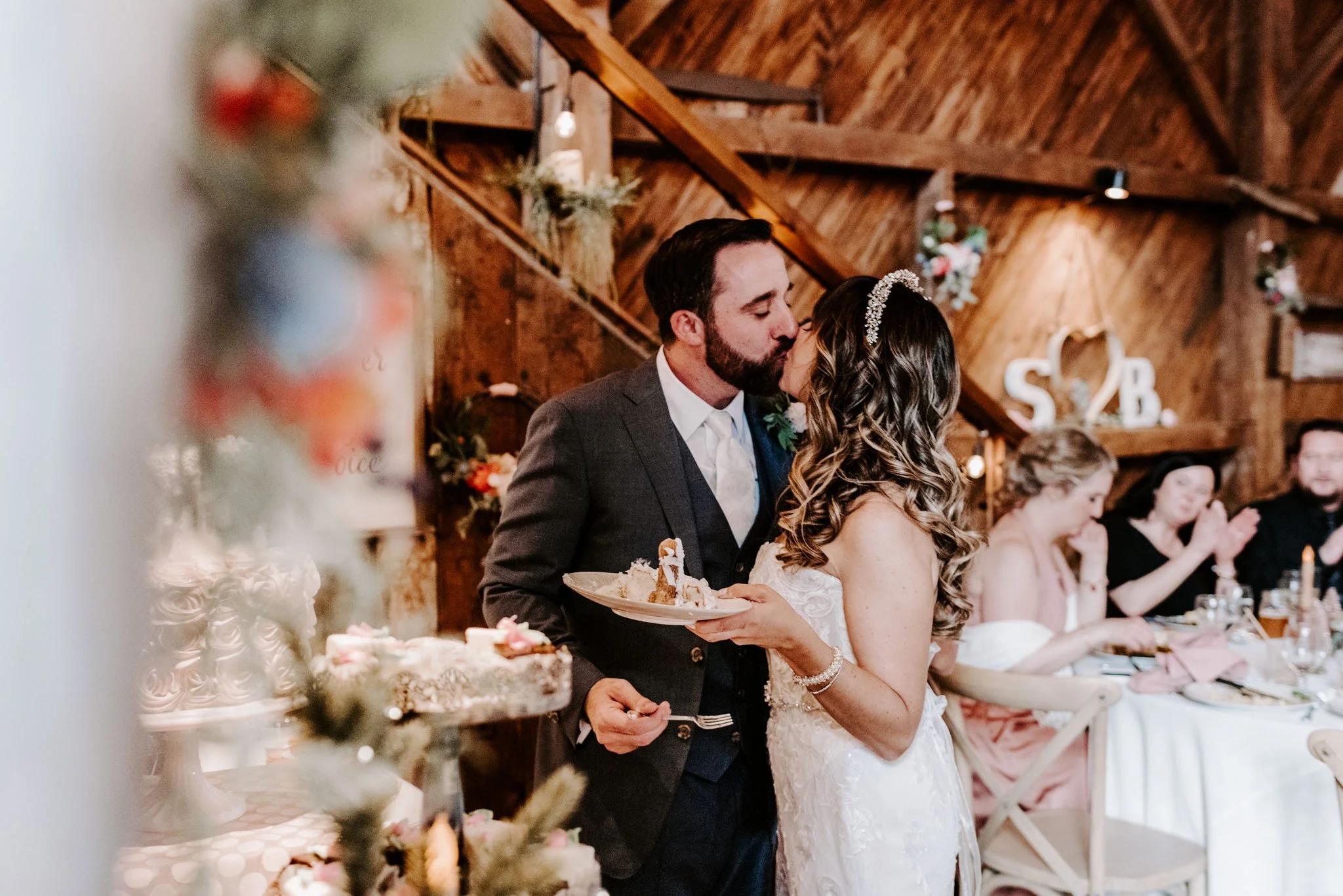 Couple cutting the cake at their rustic barn wedding