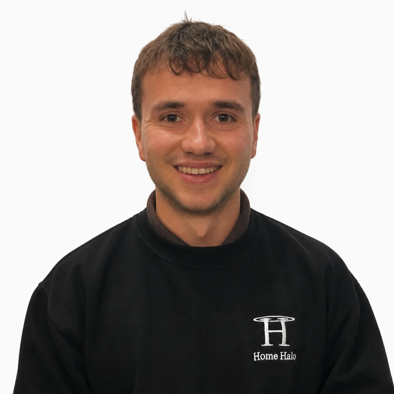 A young man smiling, wearing a black sweatshirt with a logo and text that says Home Halo, standing against a plain white background.
