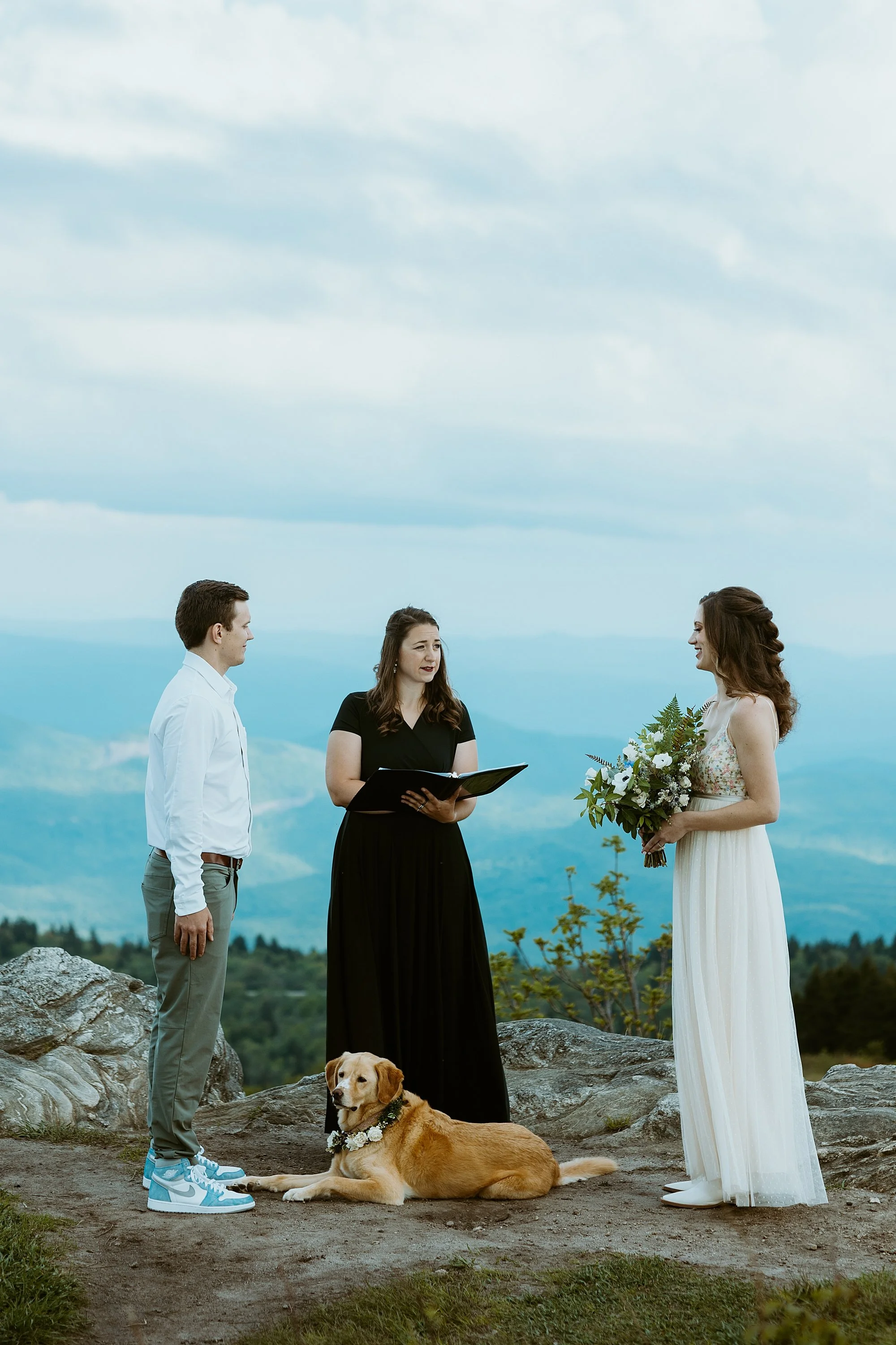 Couple is legally married on top of a mountain with their officiant overlooking the blue ridge mountains.