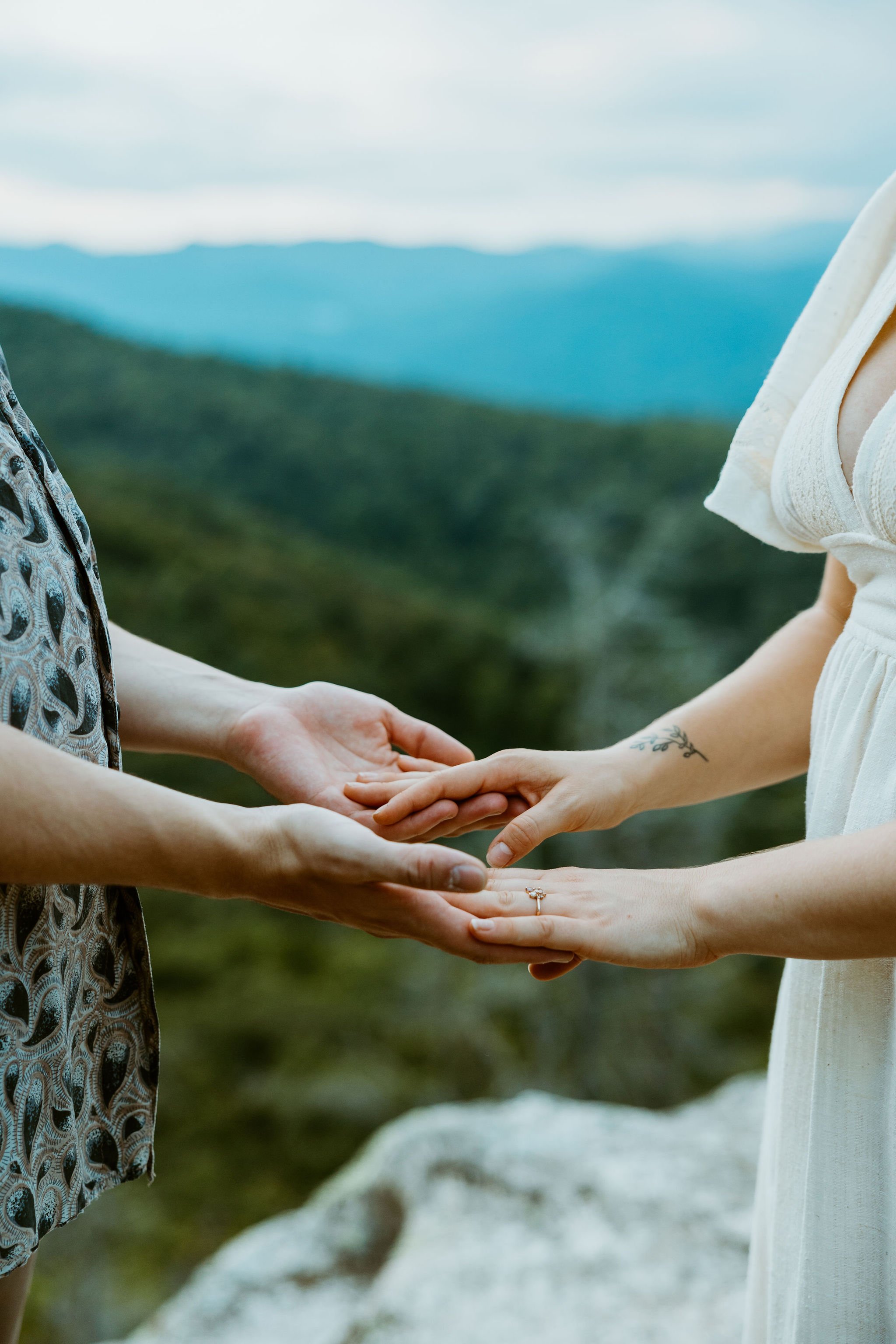Couple places their hands together while sharing their vows overlooking the blue ridge parkway.