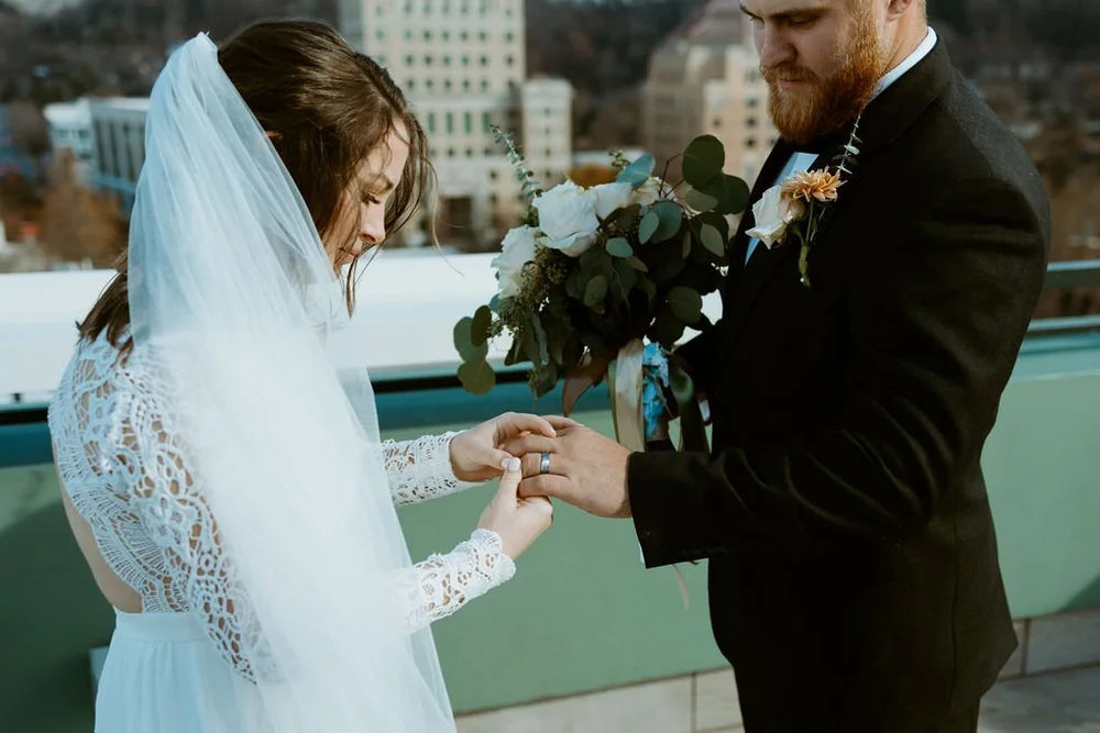 How to elope in North Carolina? Couple gets legally married at the AC Hotel in Asheville and looks at their rings afterwards.