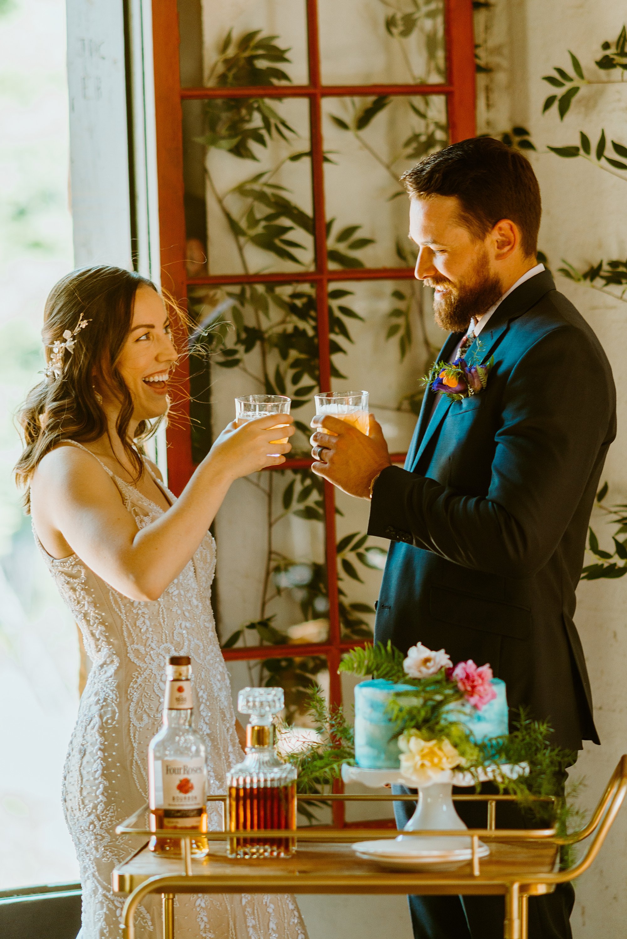 Couple celebrates their elopement with champagne at their cake table station at Black Mountain Beach Resort