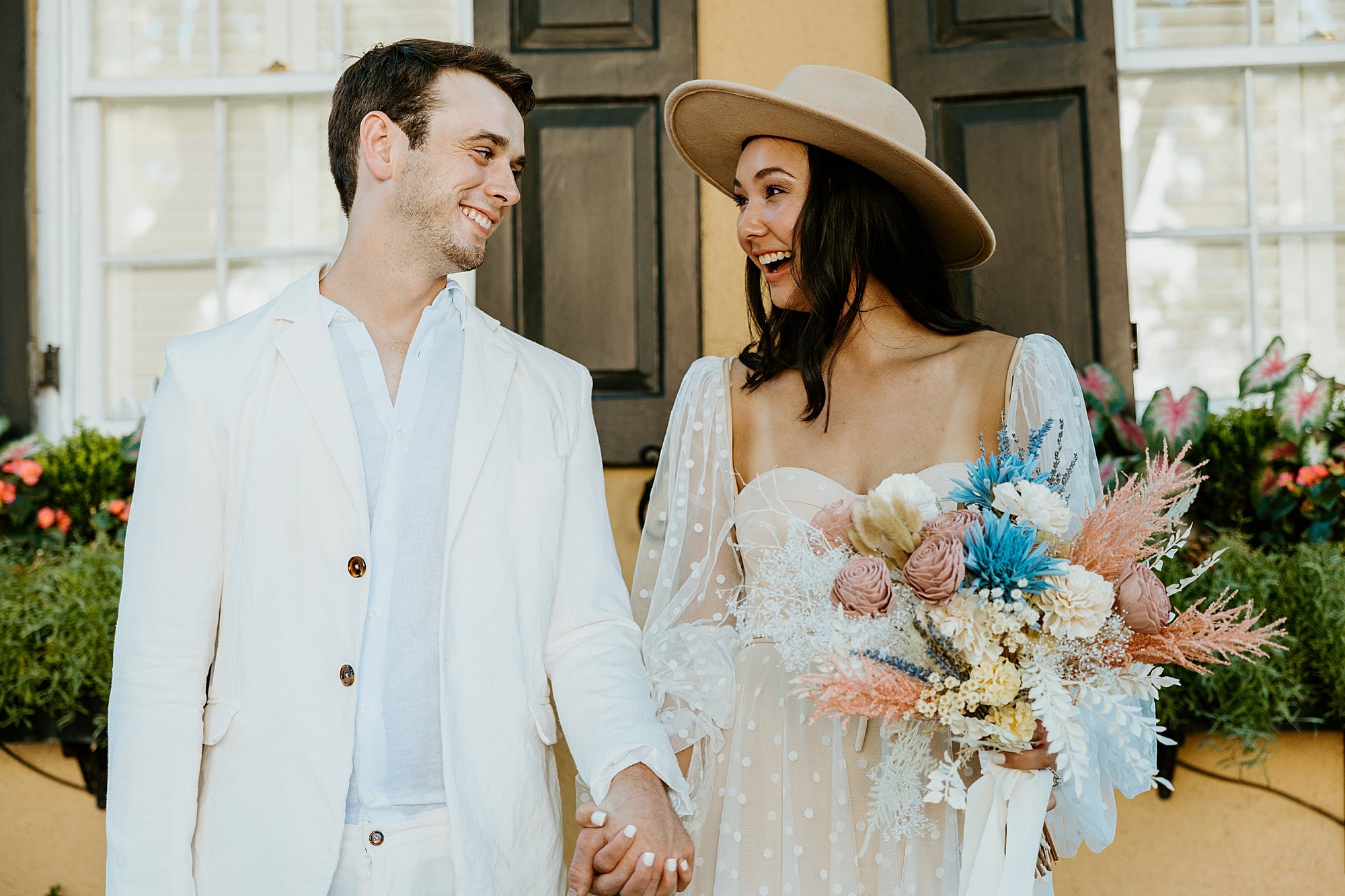 Couple laughs with each other on Rainbow Row. How to elope in Charleston SC