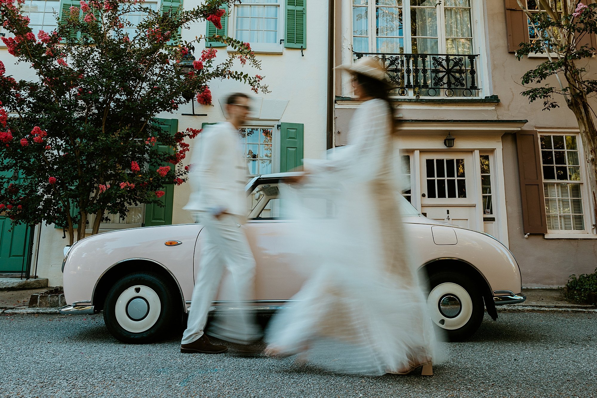 How to elope in Charleston SC. Couple walks together in front of The Pink Figgy and they are blurry.