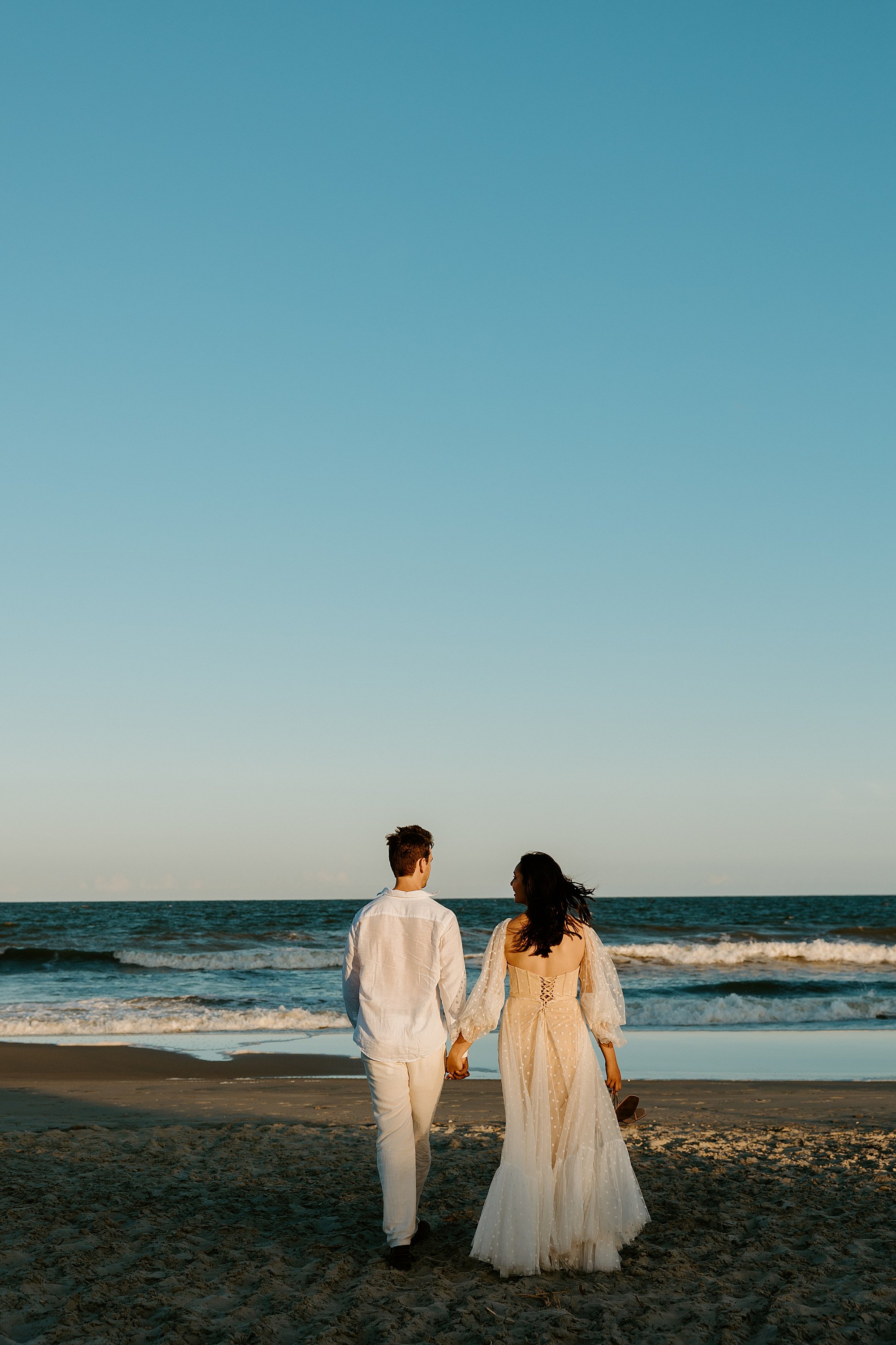 Couple walks along the beach in Charleston SC.