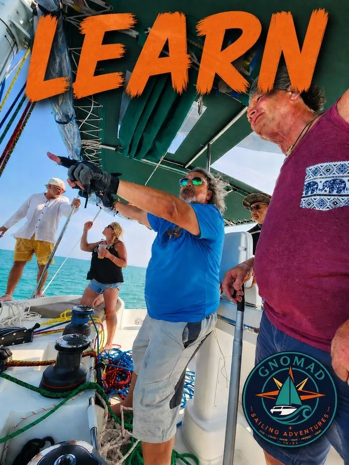Group of five people on a sailboat, with one man pointing, and the ocean in the background. Text 'LEARN' overlayed on the top.