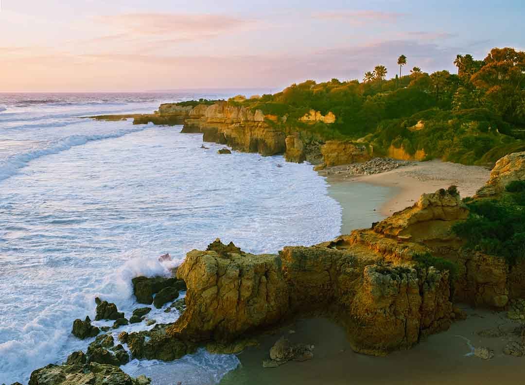 Golden cliffs and a secluded central Algarve beach photographed at sunset