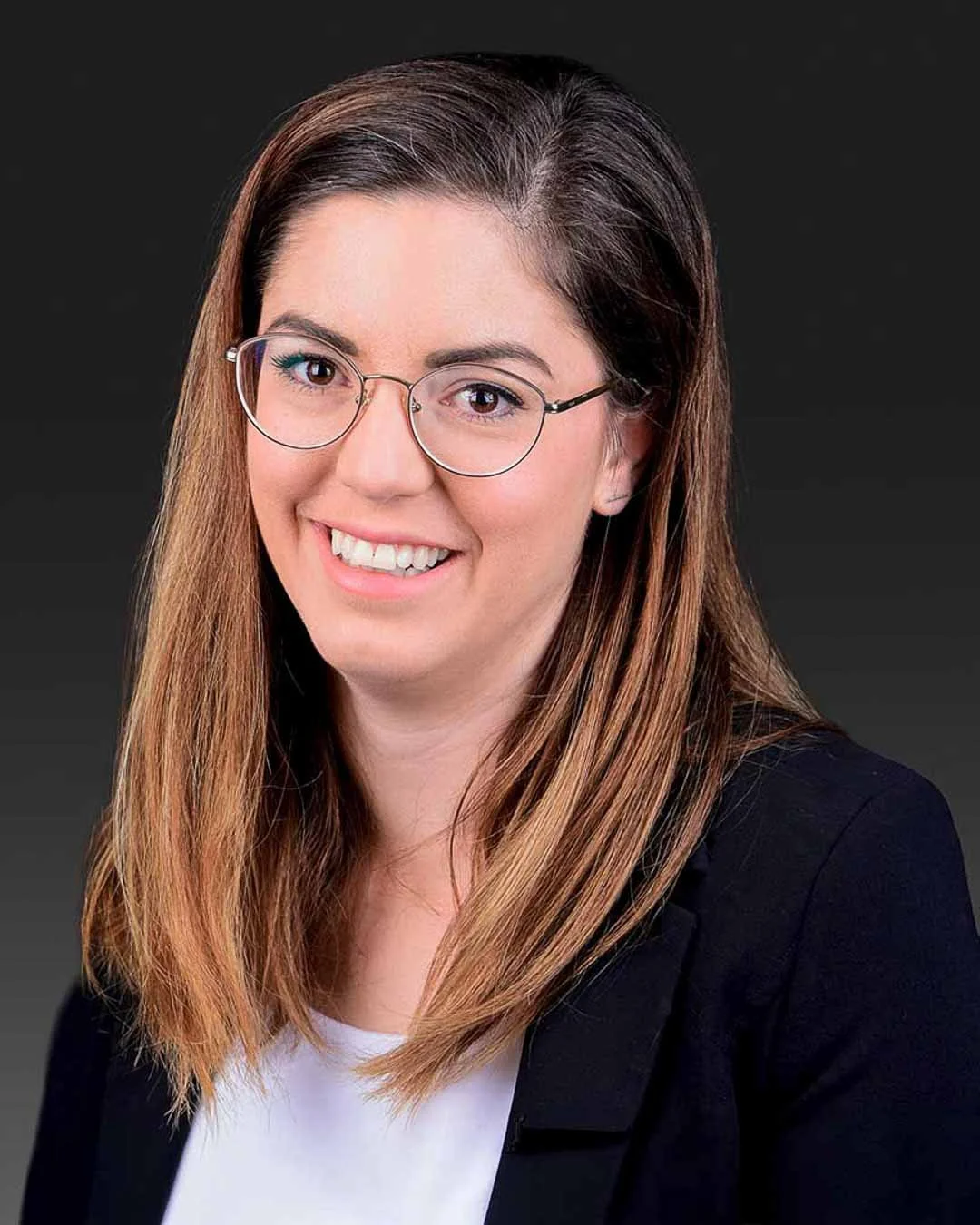 Professional studio headshot of a woman with glasses and dark blazer in the Algarve