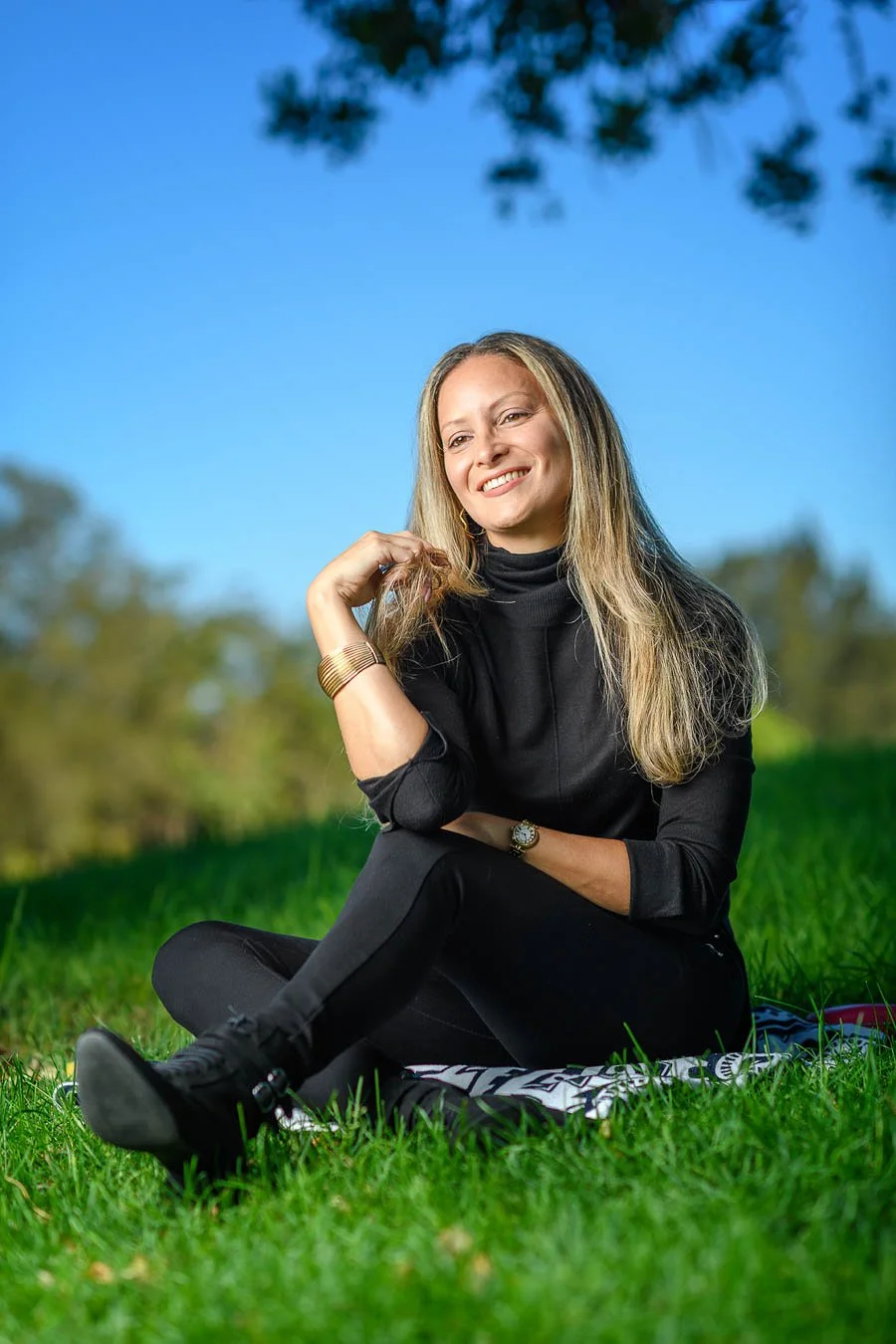 Young lady sitting on the grass under a tree