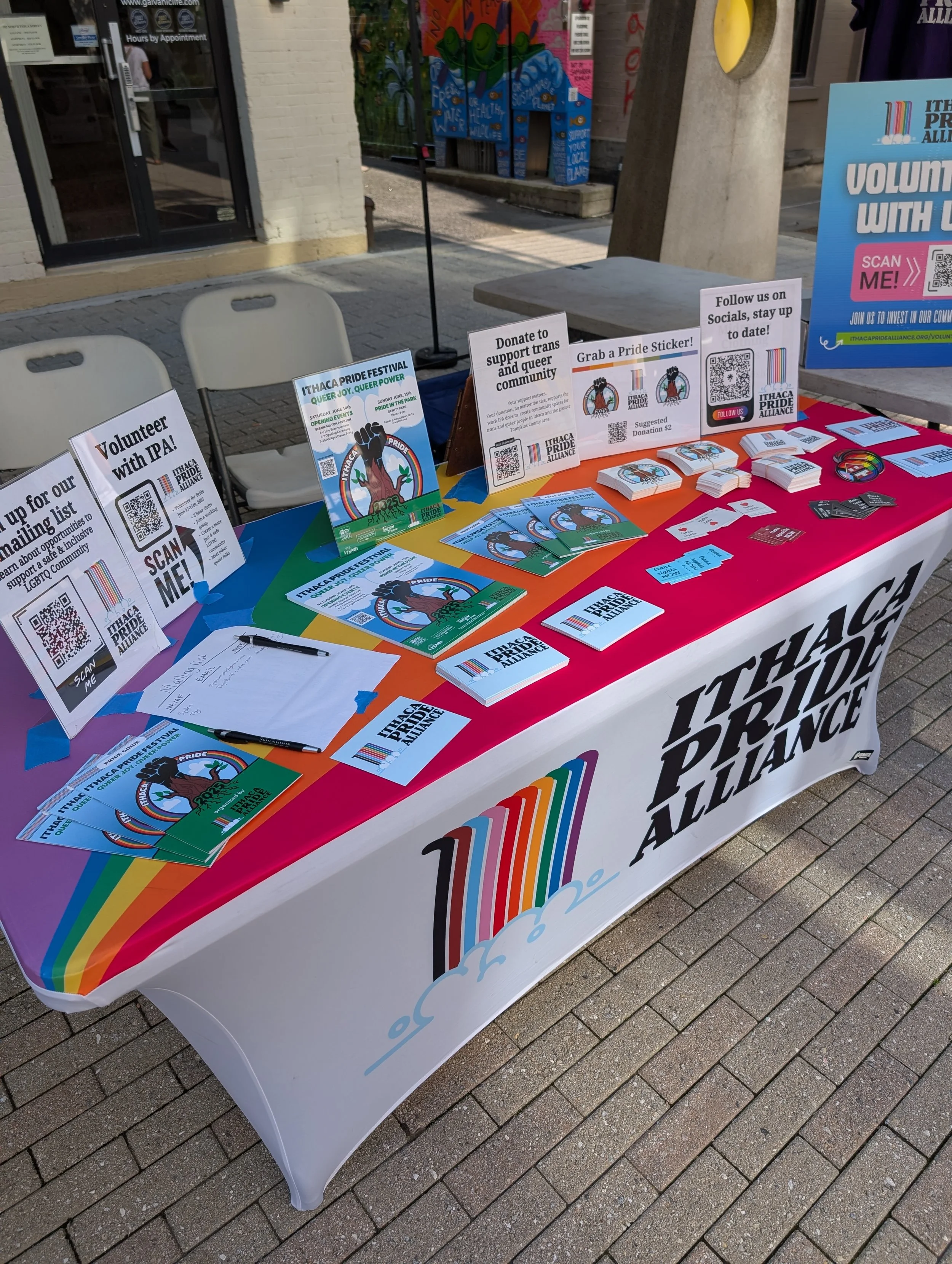Brochures and pride guides spread out on a table during a pride event