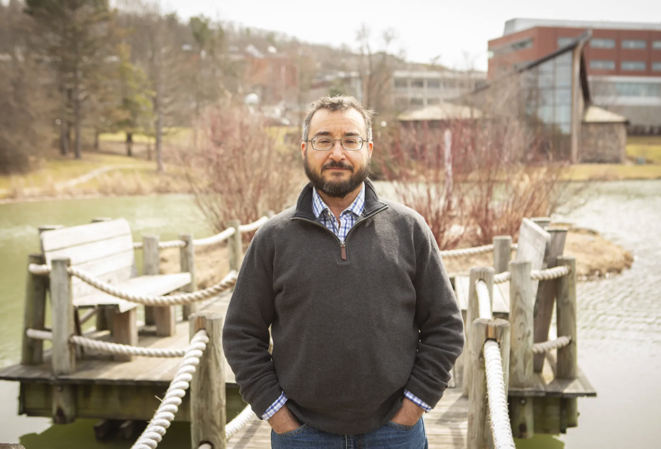 Luca Mauer stands in front of the pond at Ithaca college