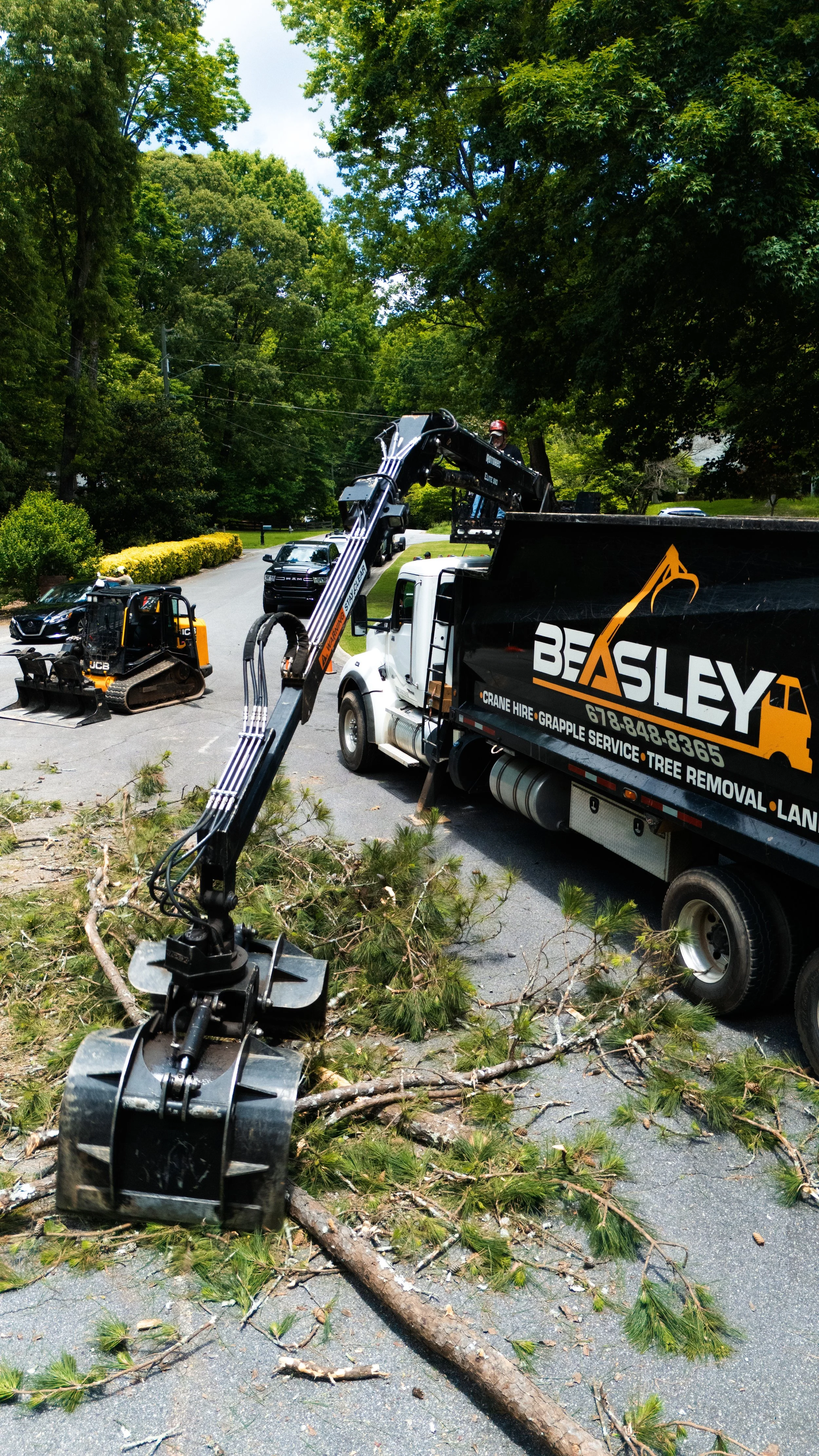 Grapple truck arm loading tree debris and brush in Cherokee County