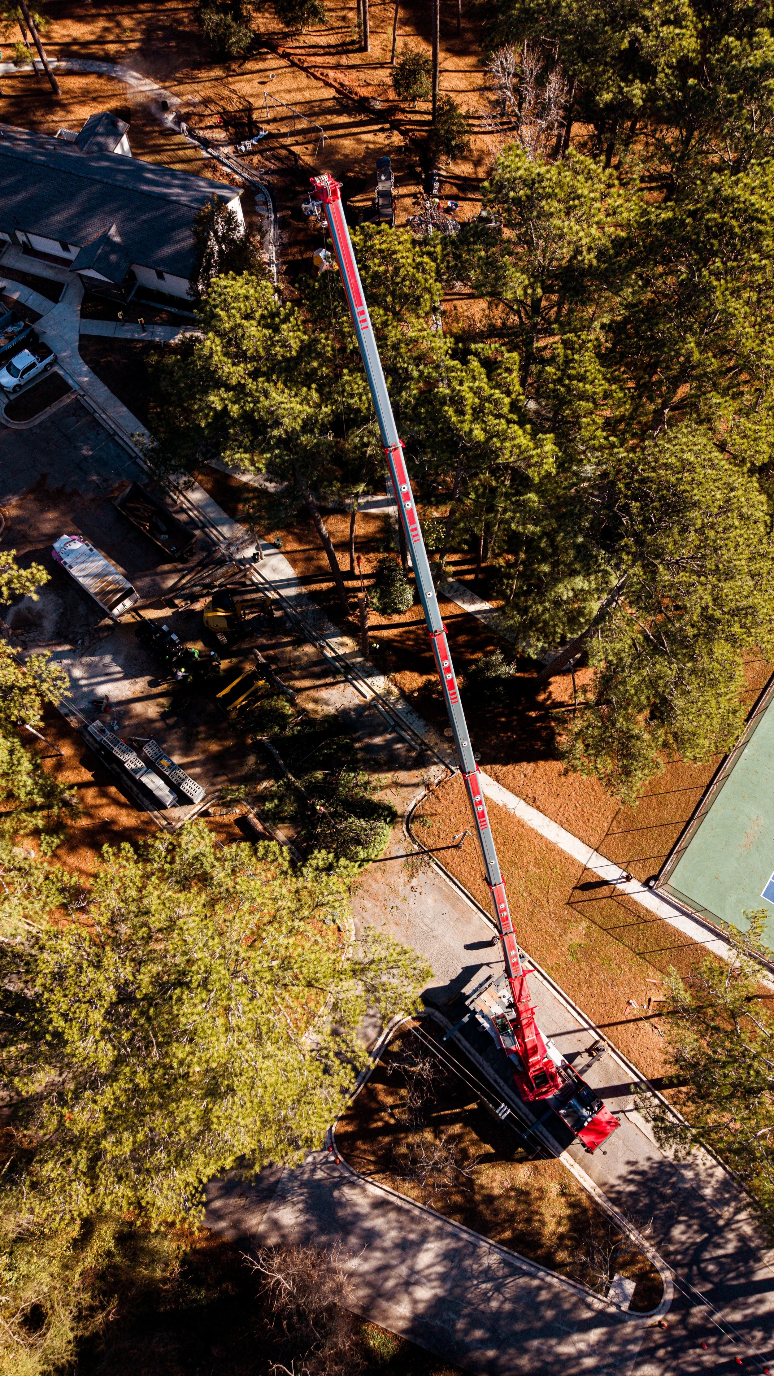 Crane performing precision vertical extraction of a tree section from a narrow ROW corridor