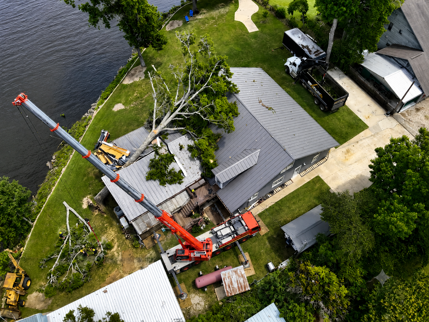 110-ton crane removing storm-damaged tree at lakeside home in Cherokee County