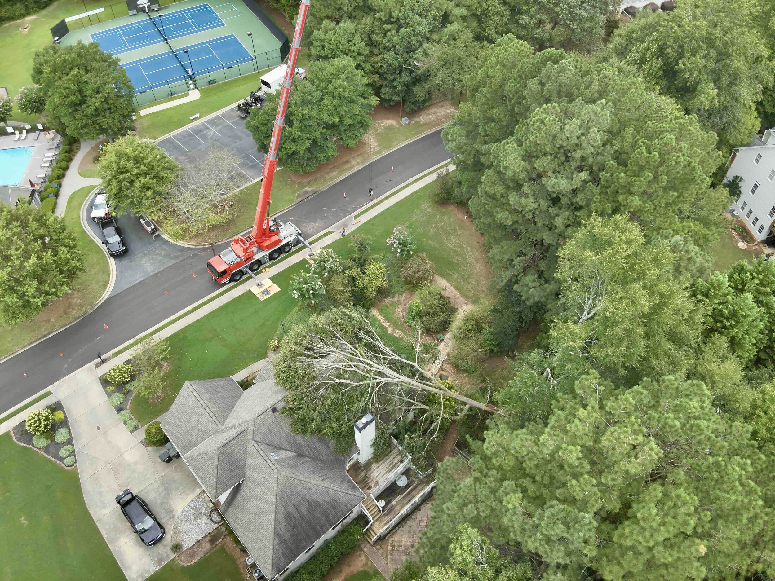Emergency tree removal after large tree fell on residential roof — Beasley Tree Experts 24/7 emergency crane service in Cherokee County and Metro Atlanta, Georgia
