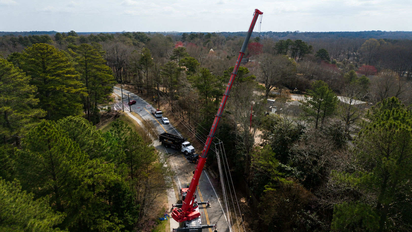 Crane truck positioned roadside for a tree removal job