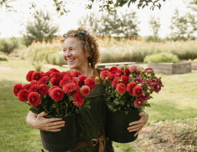 Maggie Taylor, farm owner, smiles while holding flowers