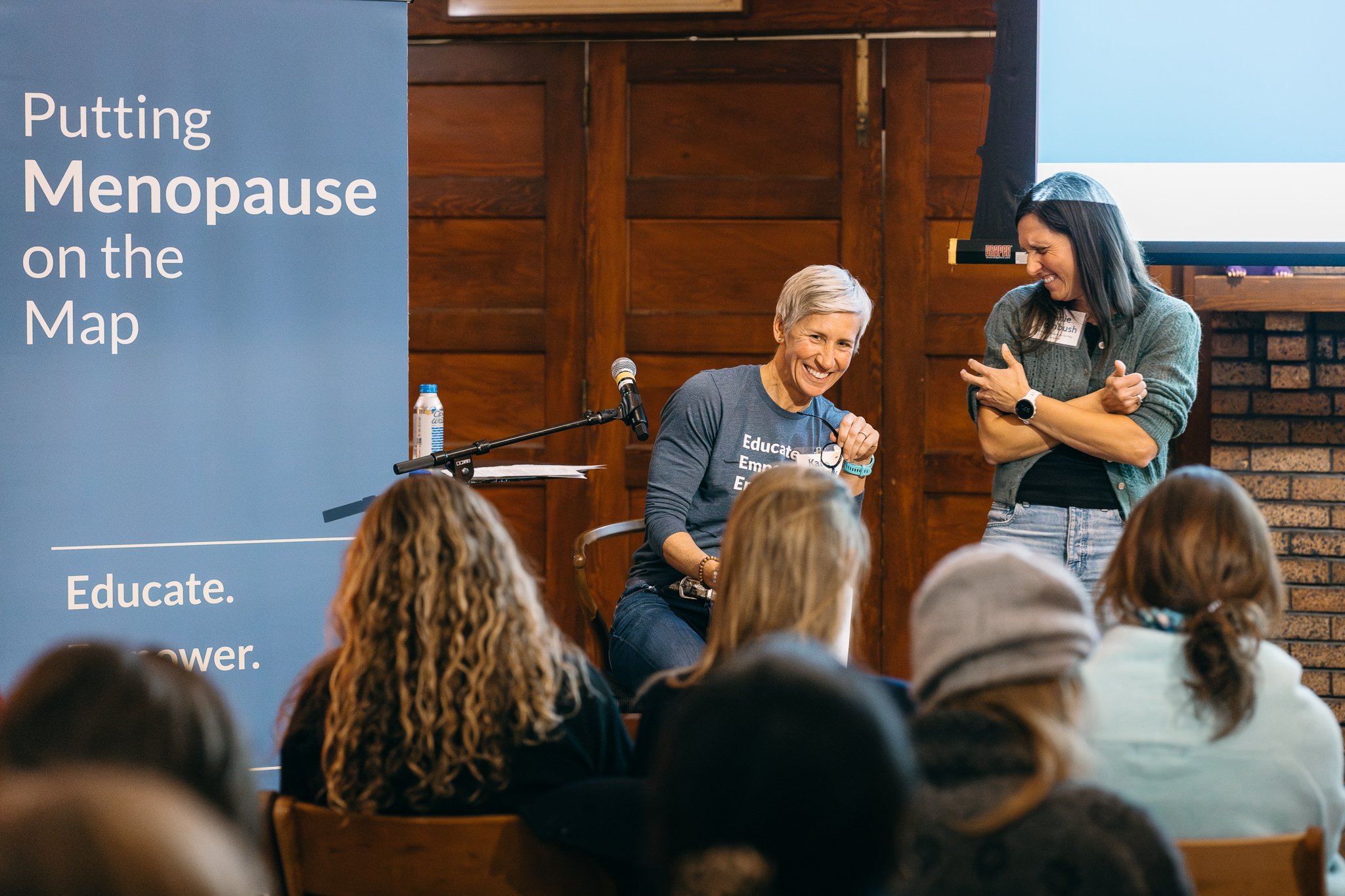 Presenter speaking to a seated audience during the Meno on Map business event, captured with a documentary approach.