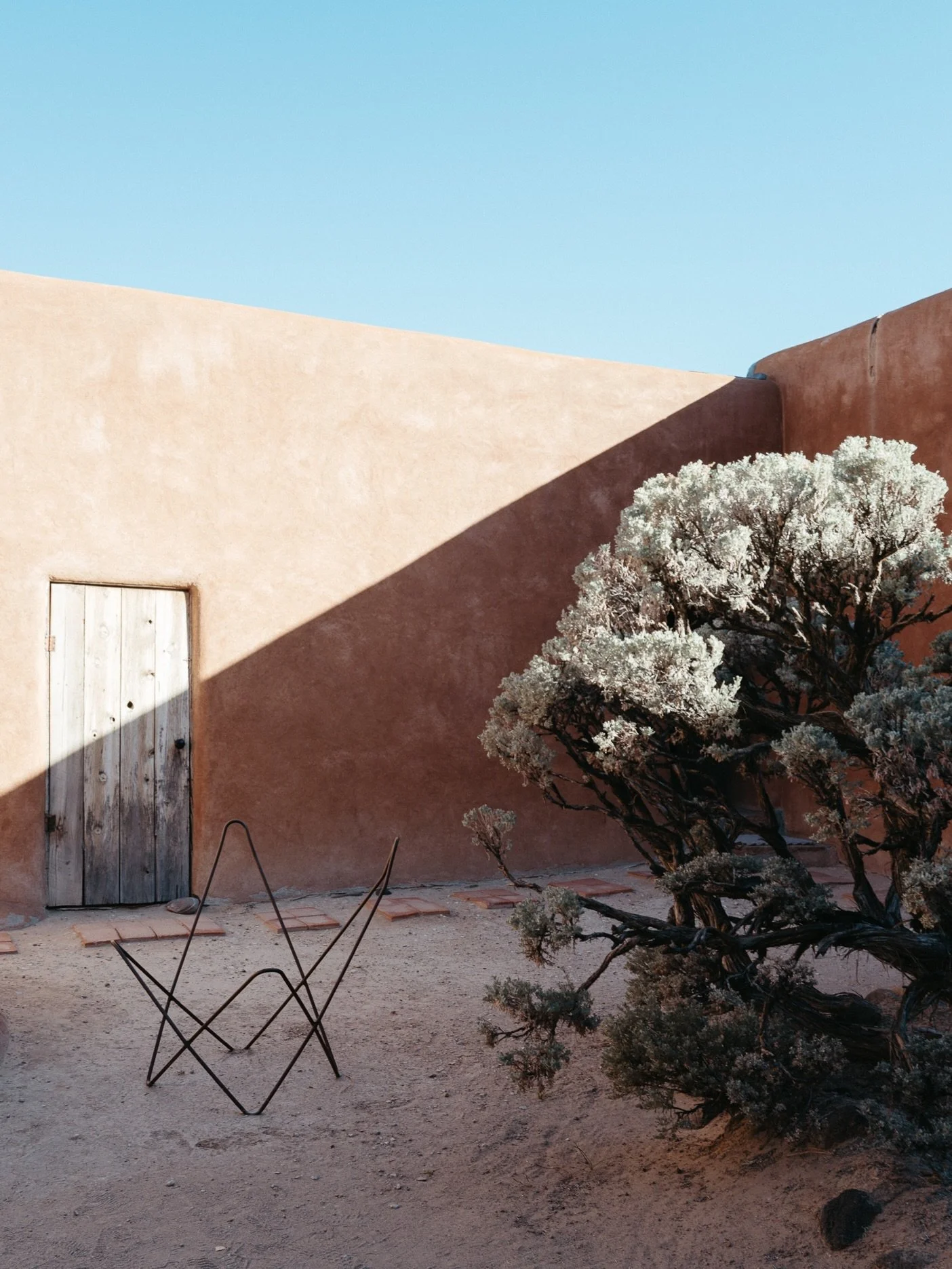 Georgia&rsquo;s patio and that butterfly chair &mdash; O&rsquo;Keeffe staples 🩵

#newmexicolife #georgiaokeeffe #abiquiu #adobe #newmexico