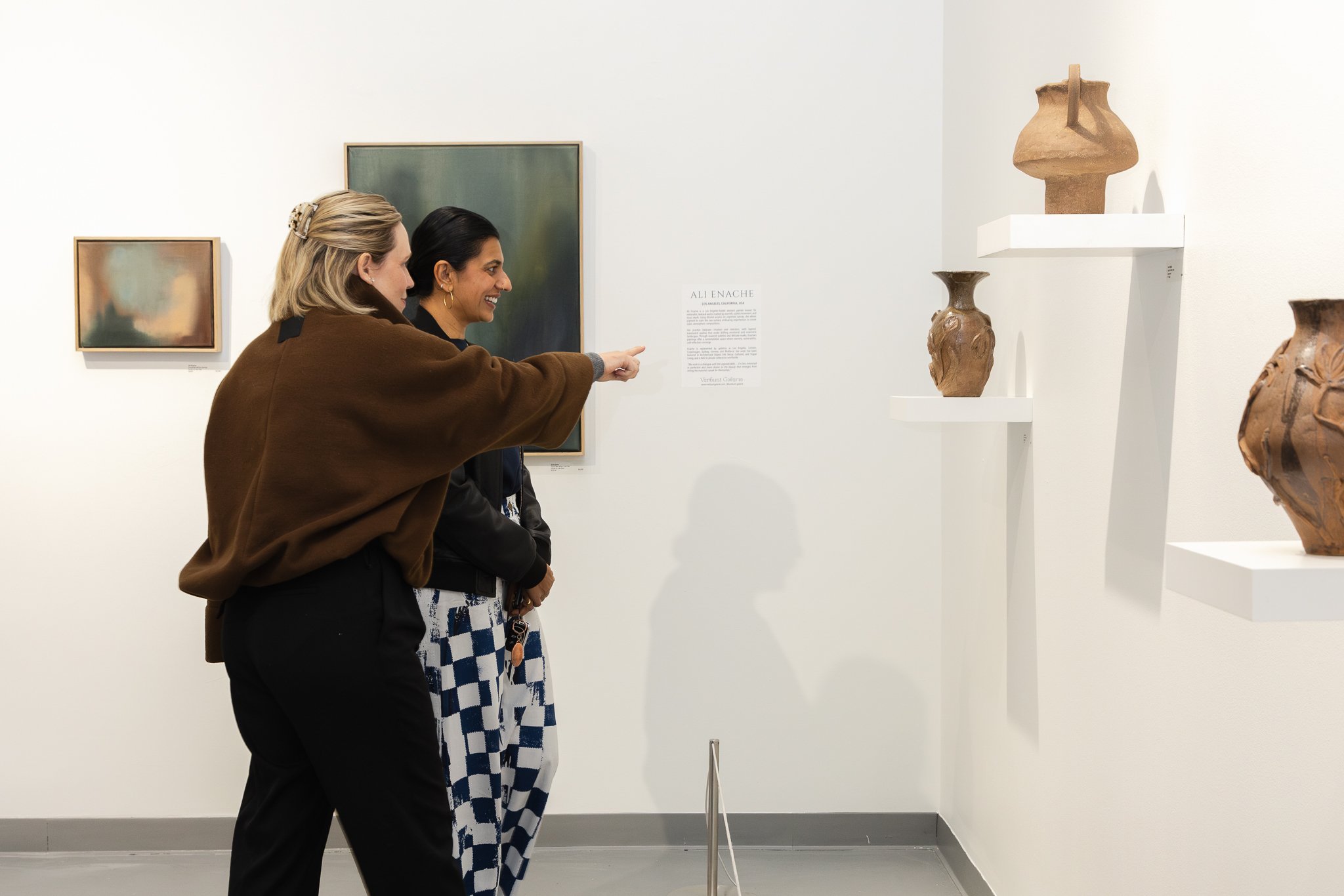 Guests viewing artwork and conversing during the Verbunt Polyglot opening event, photographed in Colorado.