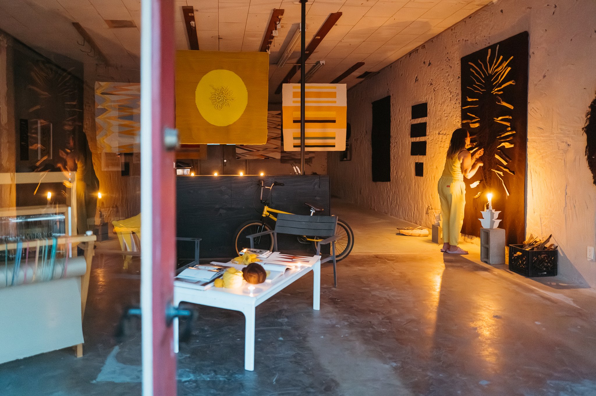 Artist weaving at a loom in a textile studio, photographed during an environmental portrait session.