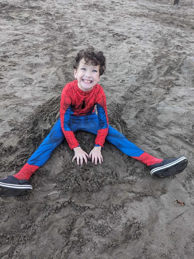 A child in a superhero costume playing outside