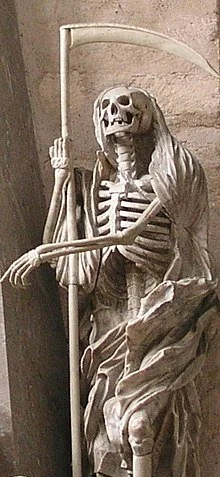 Figure 42. Statue of Death, personified as a human skeleton dressed in a shroud and clutching a scythe, at the Cathedral of Trier in Trier, Germany