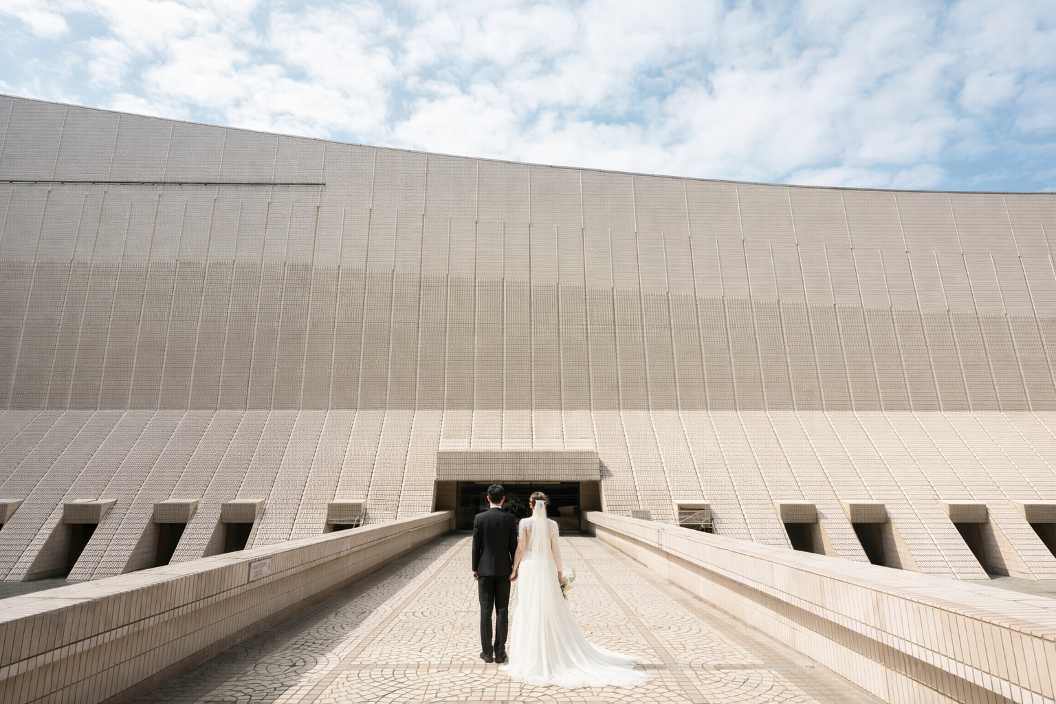 Engagement photography Auckland — couple walking hand in hand modern architecture — Wonderlens