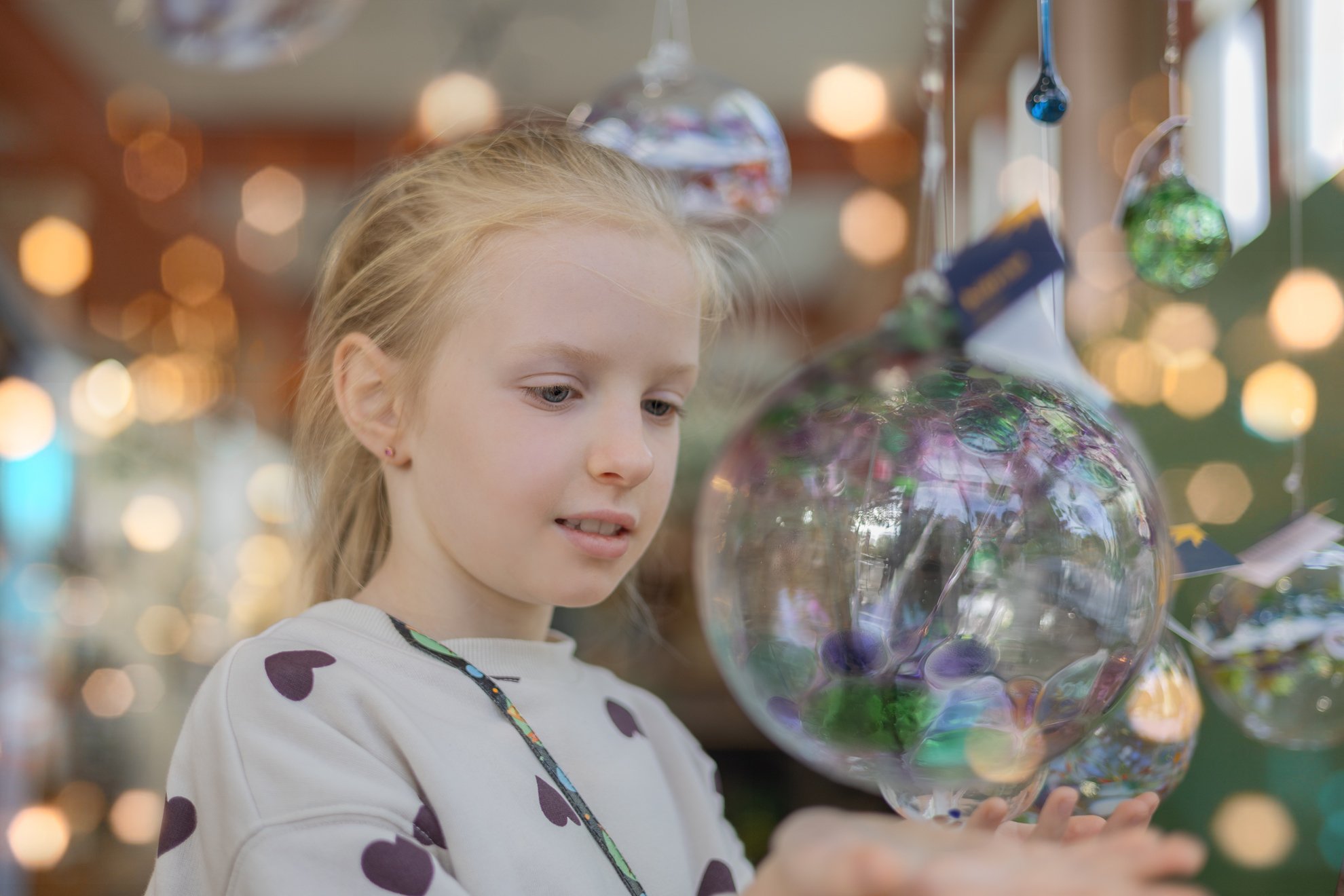 Girl looks at a Glass Ball Toy