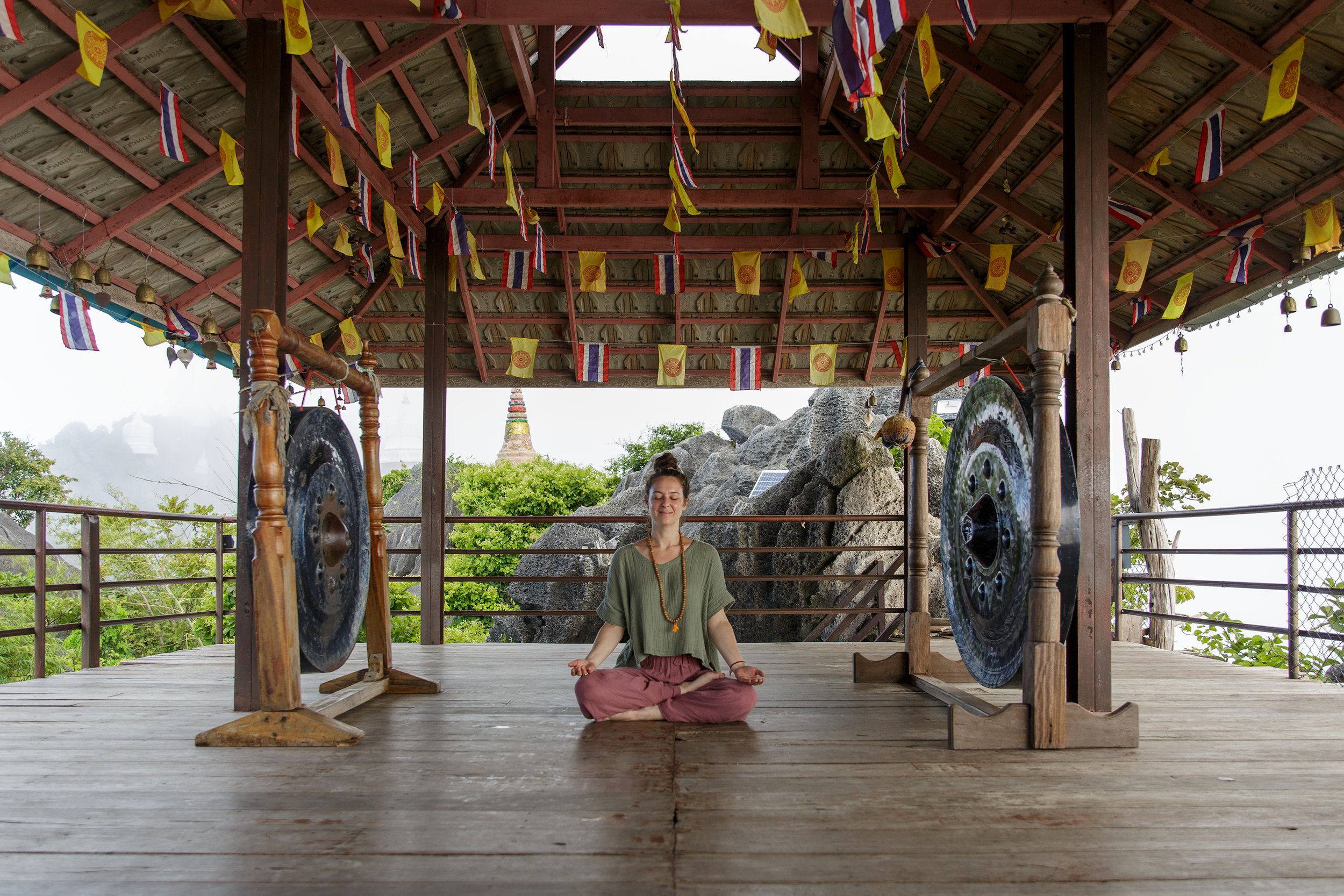 woman meditating at sky pagoda with gongs
