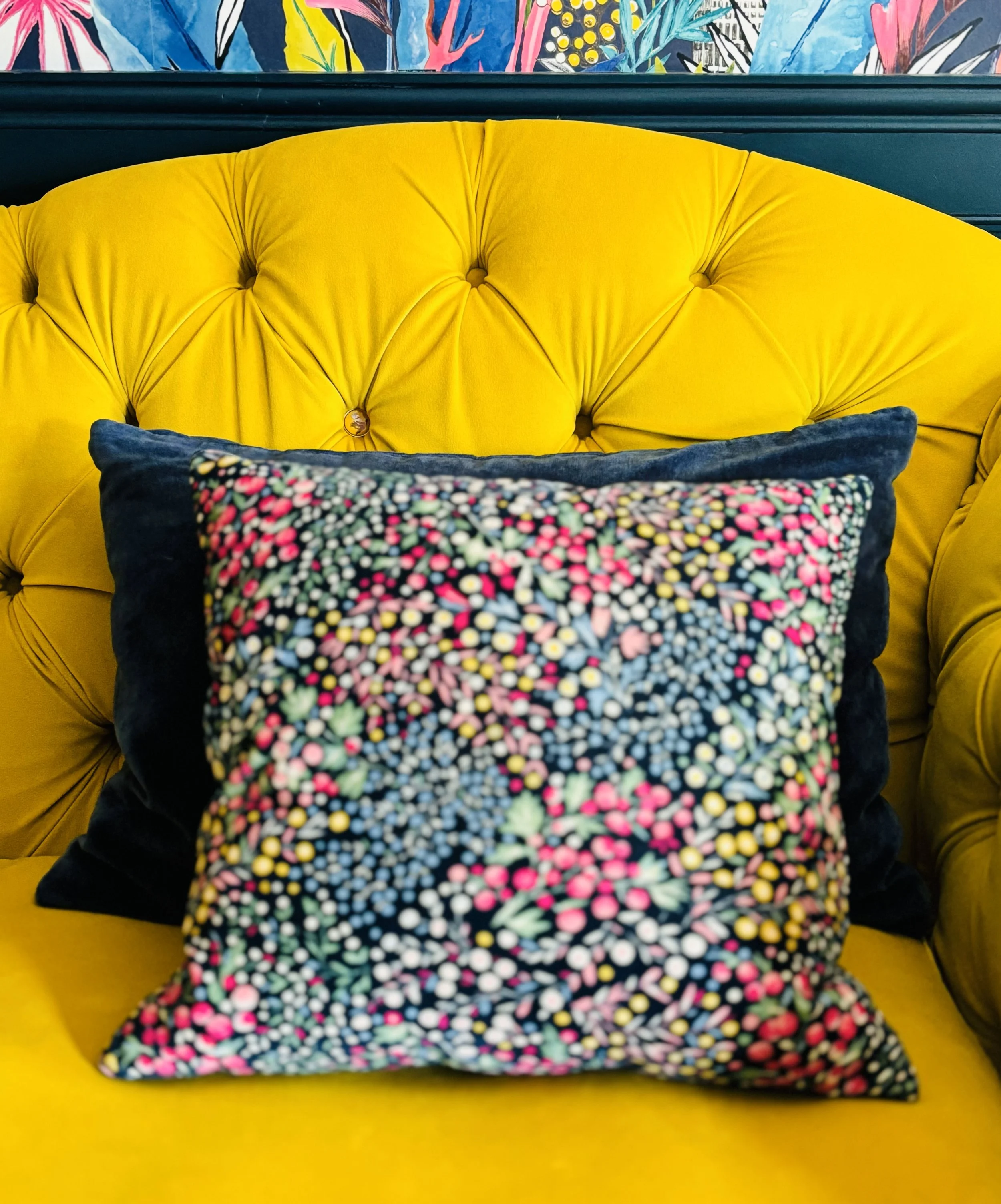 Brightly coloured cushion and button back sofa